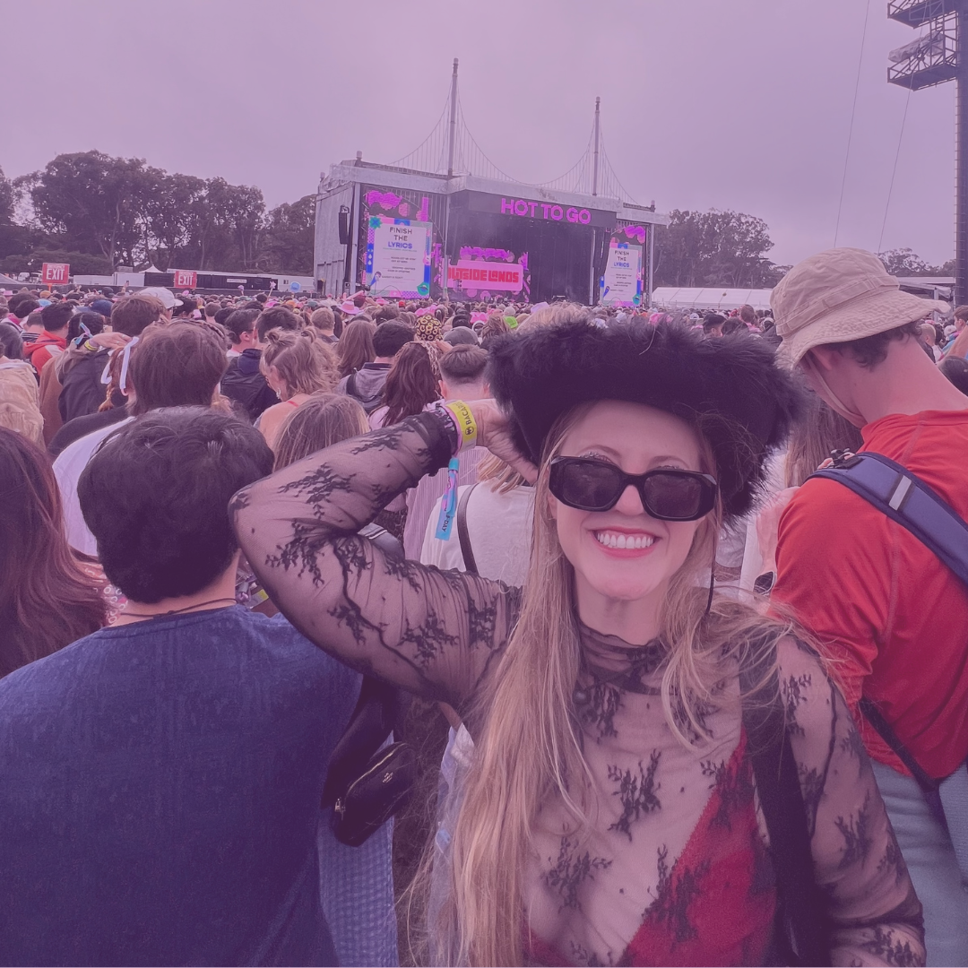 A silhouette of a person performing as a DJ on stage, illuminated by blue spotlight and surrounded by dark ambient lighting and fog.