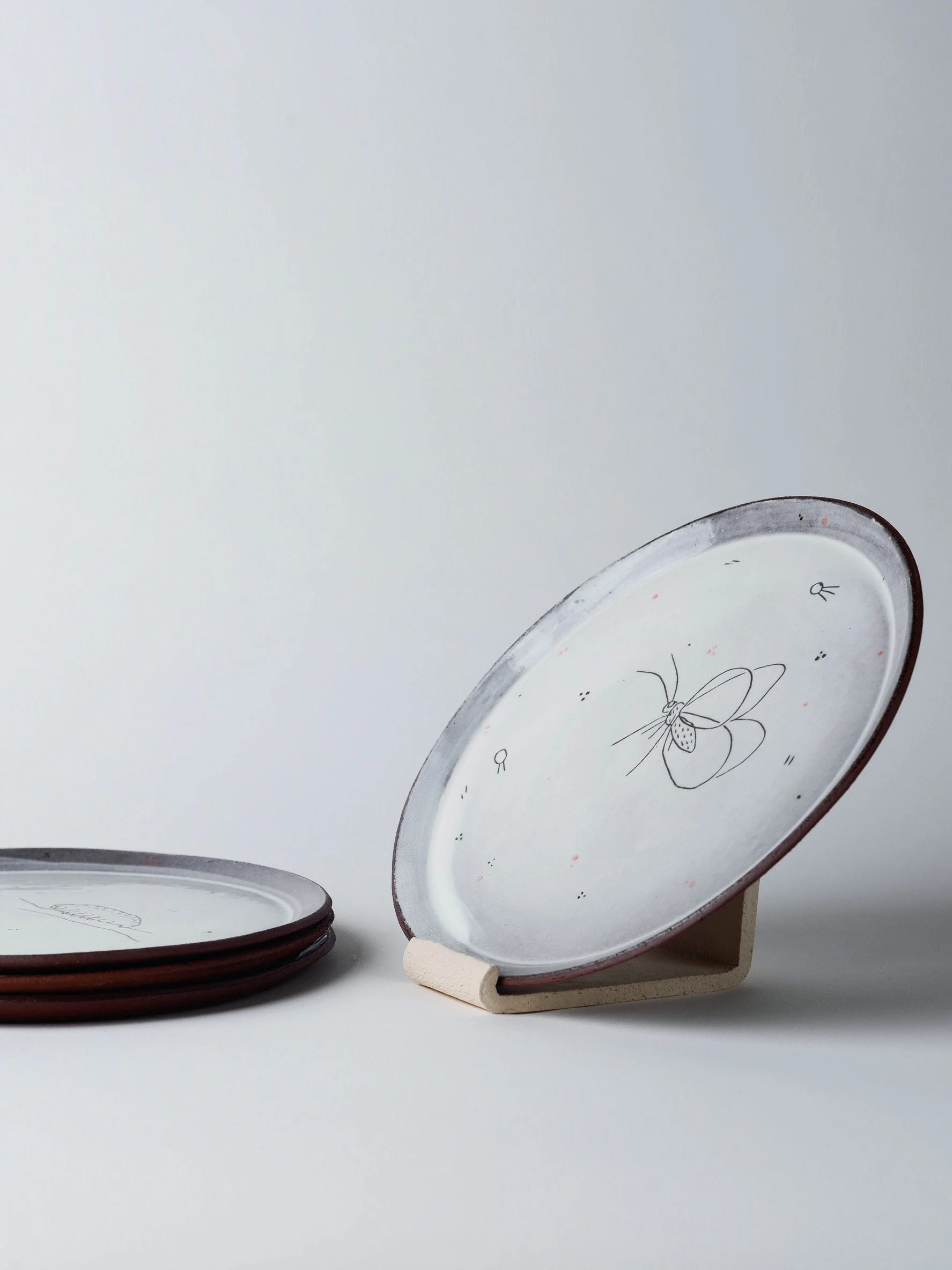 Seitliche Ansicht eines grossen Tellers mit Schmetterling im sgraffito, handgemachte Keramik aus dem Atelier KOBO Zürich