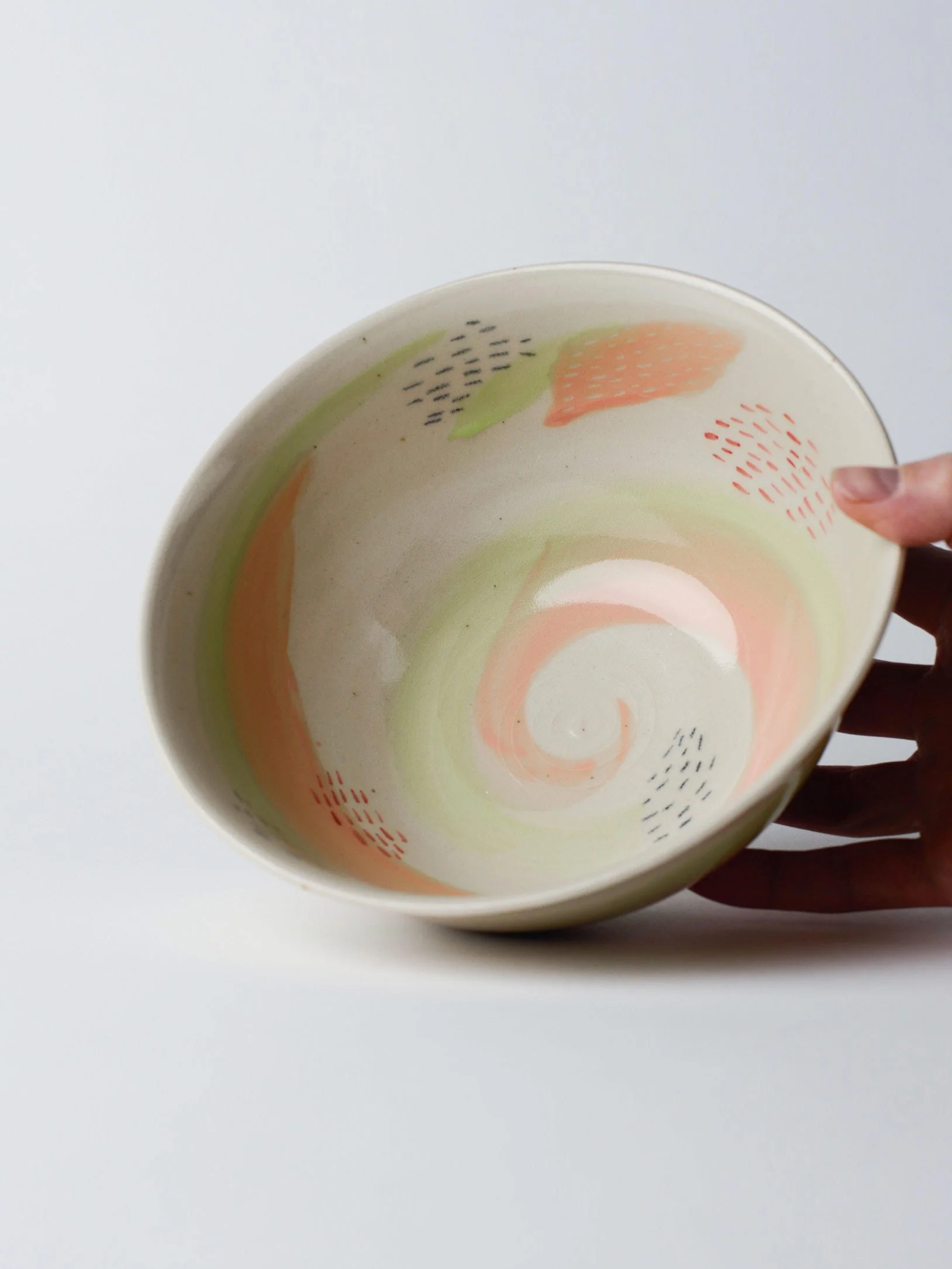 Udon-Schale mit zartgrünem Pinselstrich – gekippte Schale in der Hand, Innenglasur sichtbar.