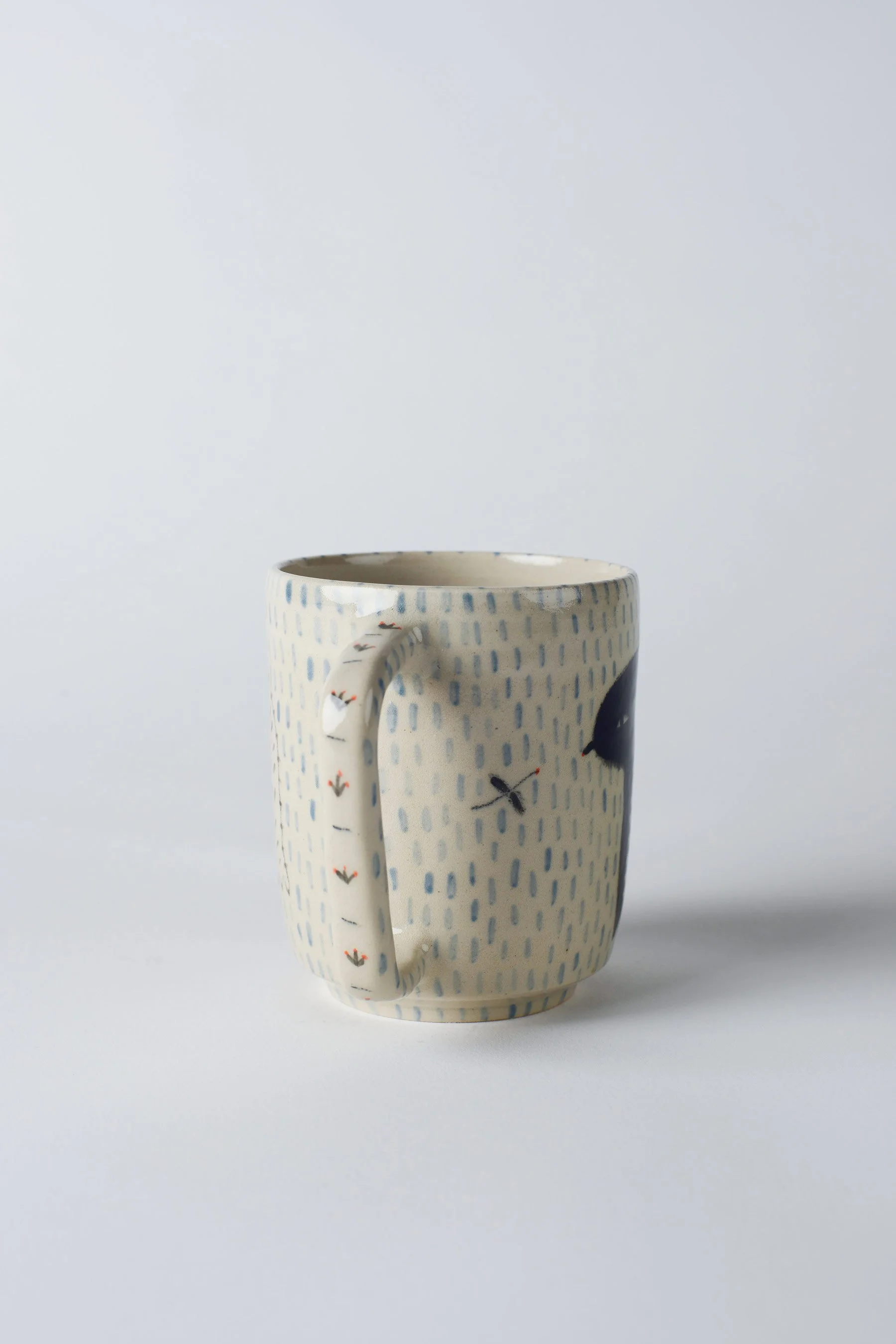 Ko-hi-Tasse mit dem schwarzen, langbeinigen Wesen – letzte Rundumansicht der gezeichneten Keramik.