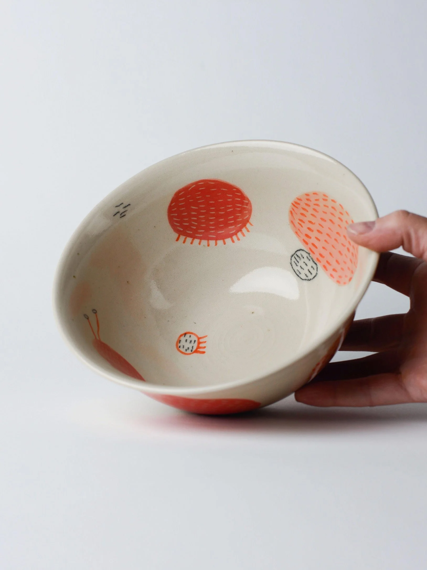 Udon-Schale mit gezeichneten roten Wesen – in der Hand gehaltene Schale, Einblick in die Innenglasur.