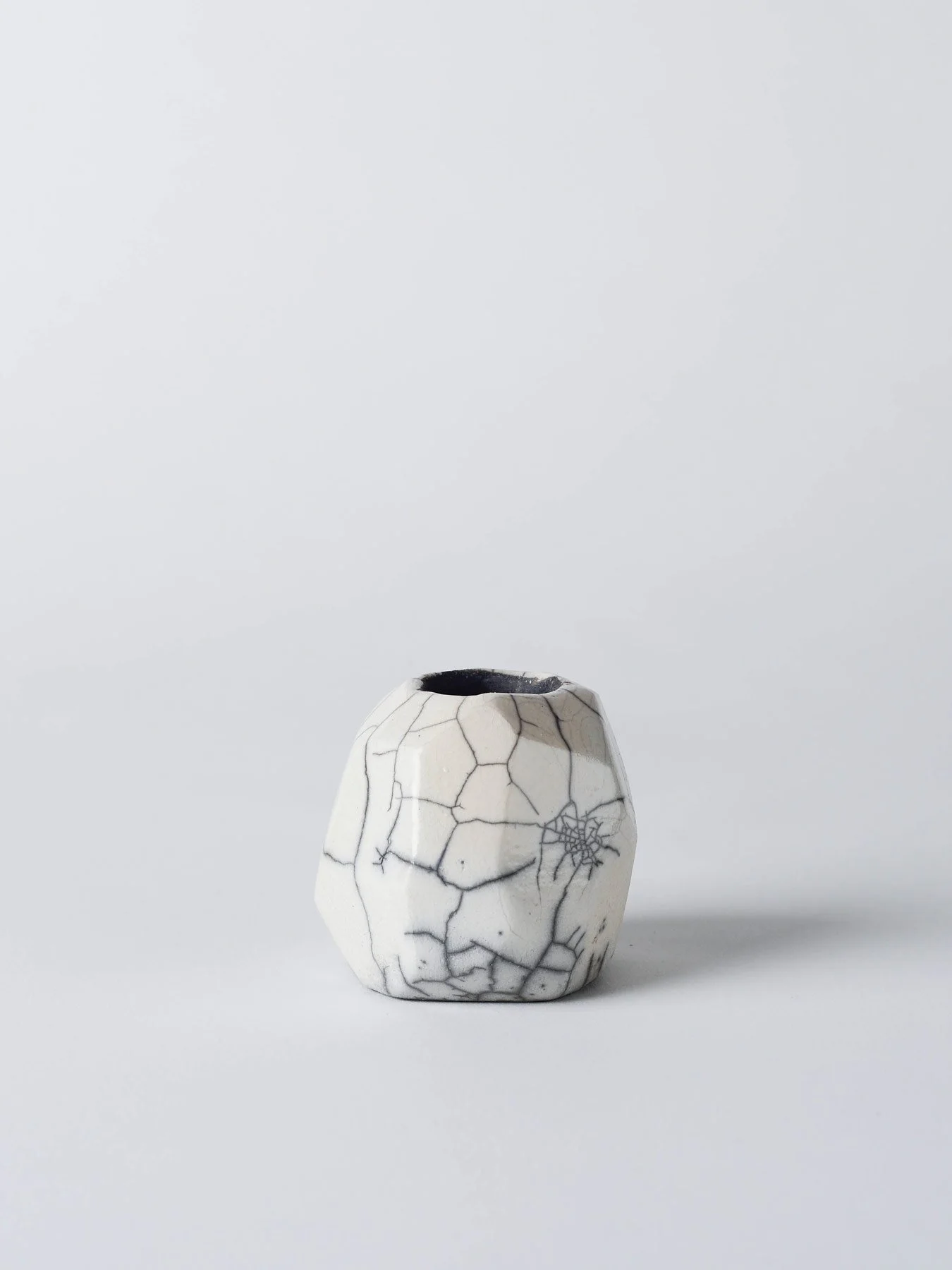 Raku-Kerzenständer mit facettierter Form und Craquelé-Struktur in der Frontansicht