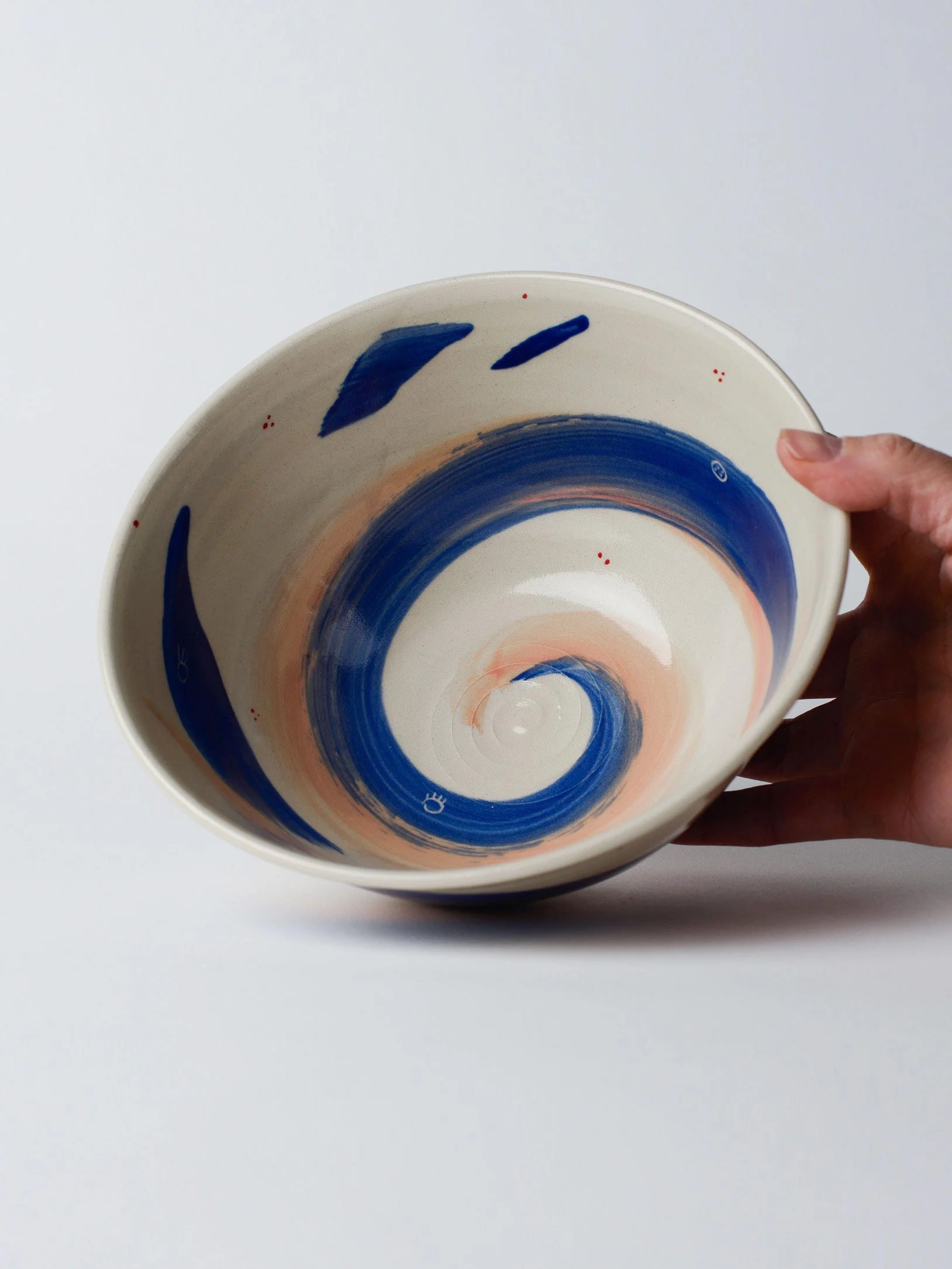 Udon-Schale mit blauen und rosa Pinselstrichen – gekippte Aufnahme, bei der die Innenglasur sichtbar wird.