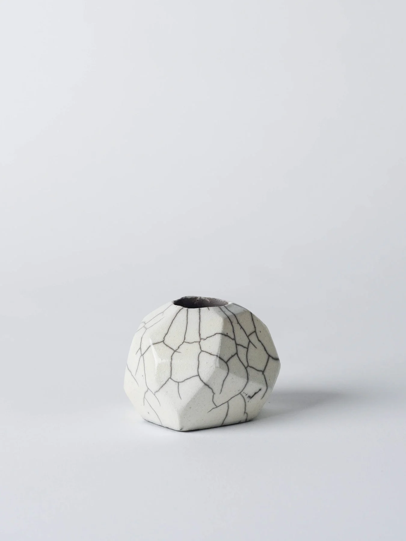 Raku-Kerzenständer mit facettierter Form und Craquelé-Struktur in der Frontansicht