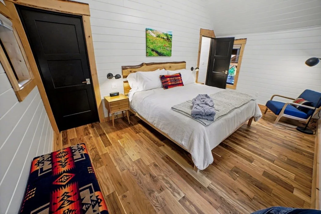King bed with hand-knit throw and forest views in Fjellsangin luxury cabin bedroom