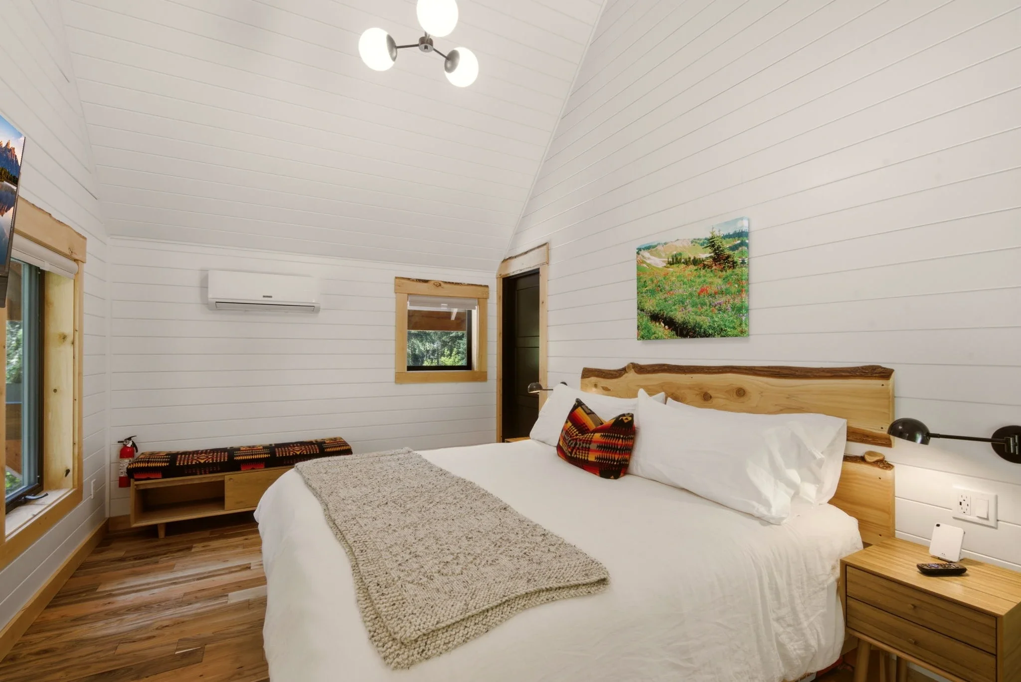 Upper-floor king bedroom with vaulted ceiling and sputnik chandelier at Fjellsangin cabin near Mount Rainier