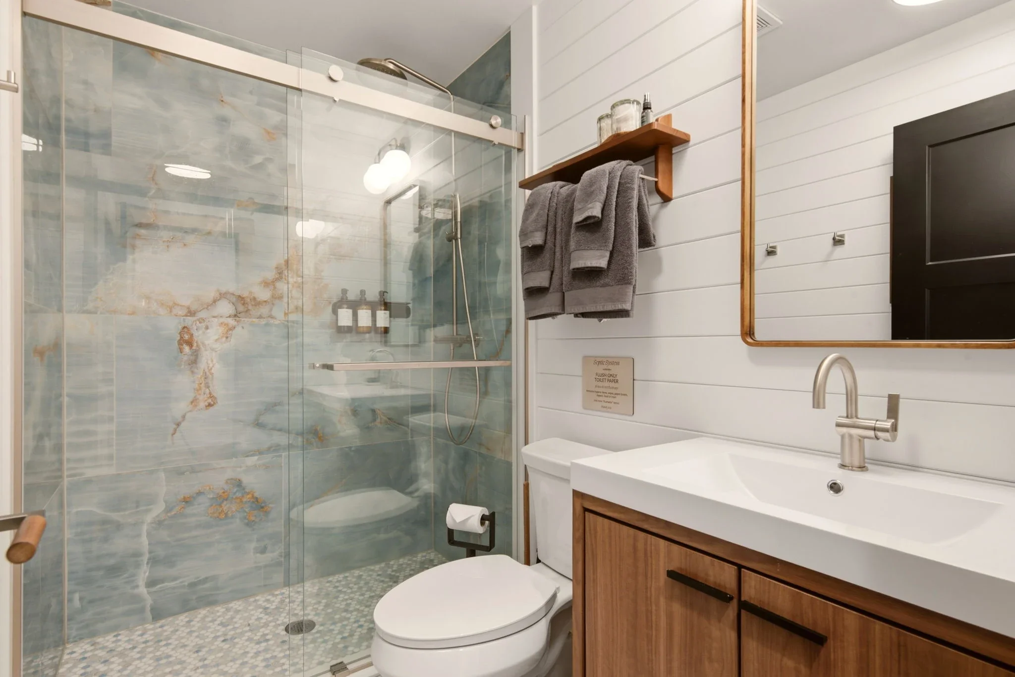 Bathroom with blue and gold marble-tile shower and walnut vanity at Fjellsangin cabin near Mount Rainier