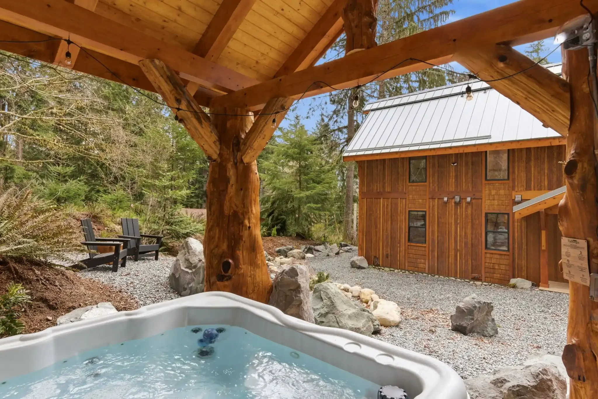 Hot tub pavilion looking toward cabin with Adirondack chairs at Fjellsangin