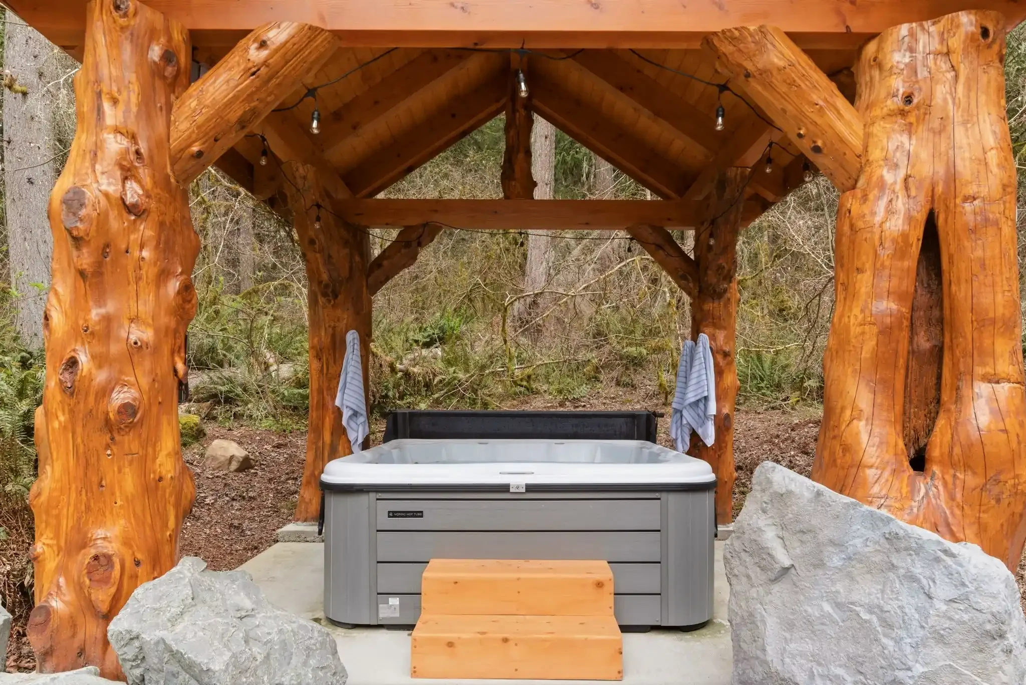 Covered hot tub pavilion with cedar log posts at Fjellsangin, hot tub cabin, Washington