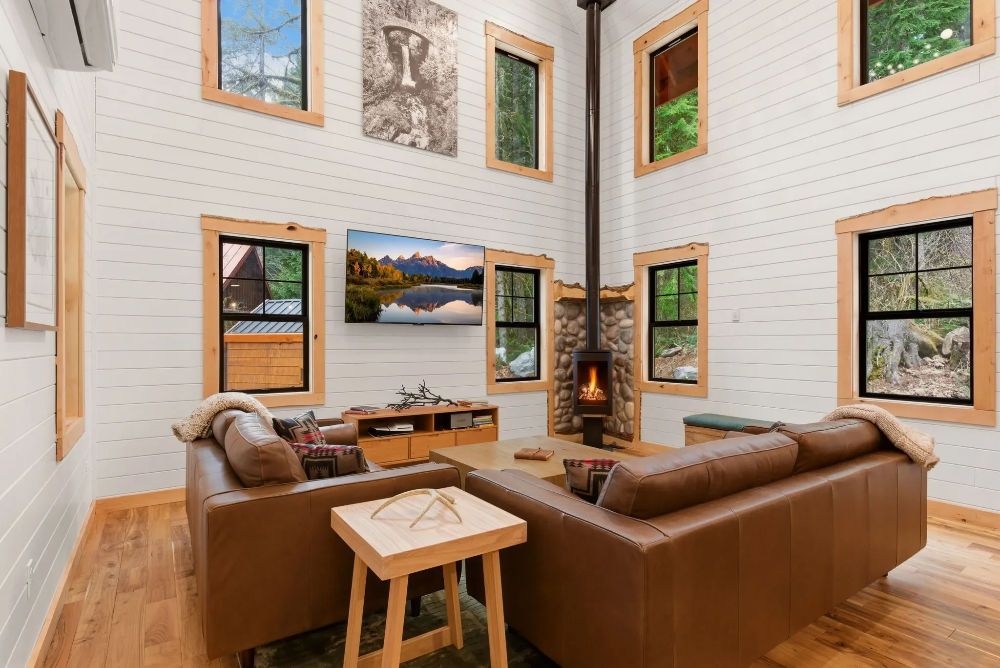 Jøtul gas fireplace with river rock surround in Fjellsangin's great room, luxury cabin near Mount Rainier