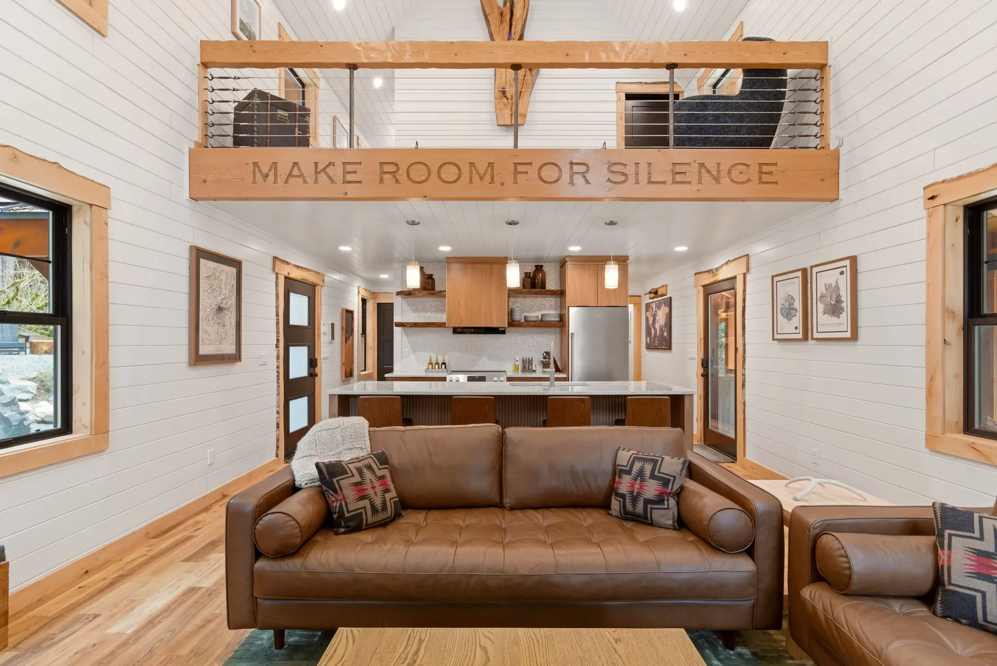 Wide angle of the great room at Fjellsangin showing the 'make room for silence' beam and kitchen below