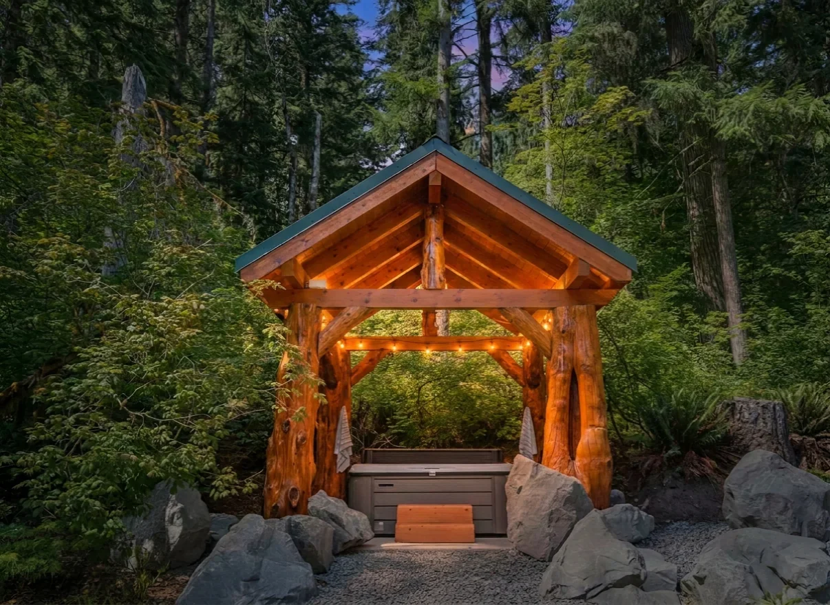 Covered hot tub pavilion with cedar log posts at Fjellsangin after a summer hiking day