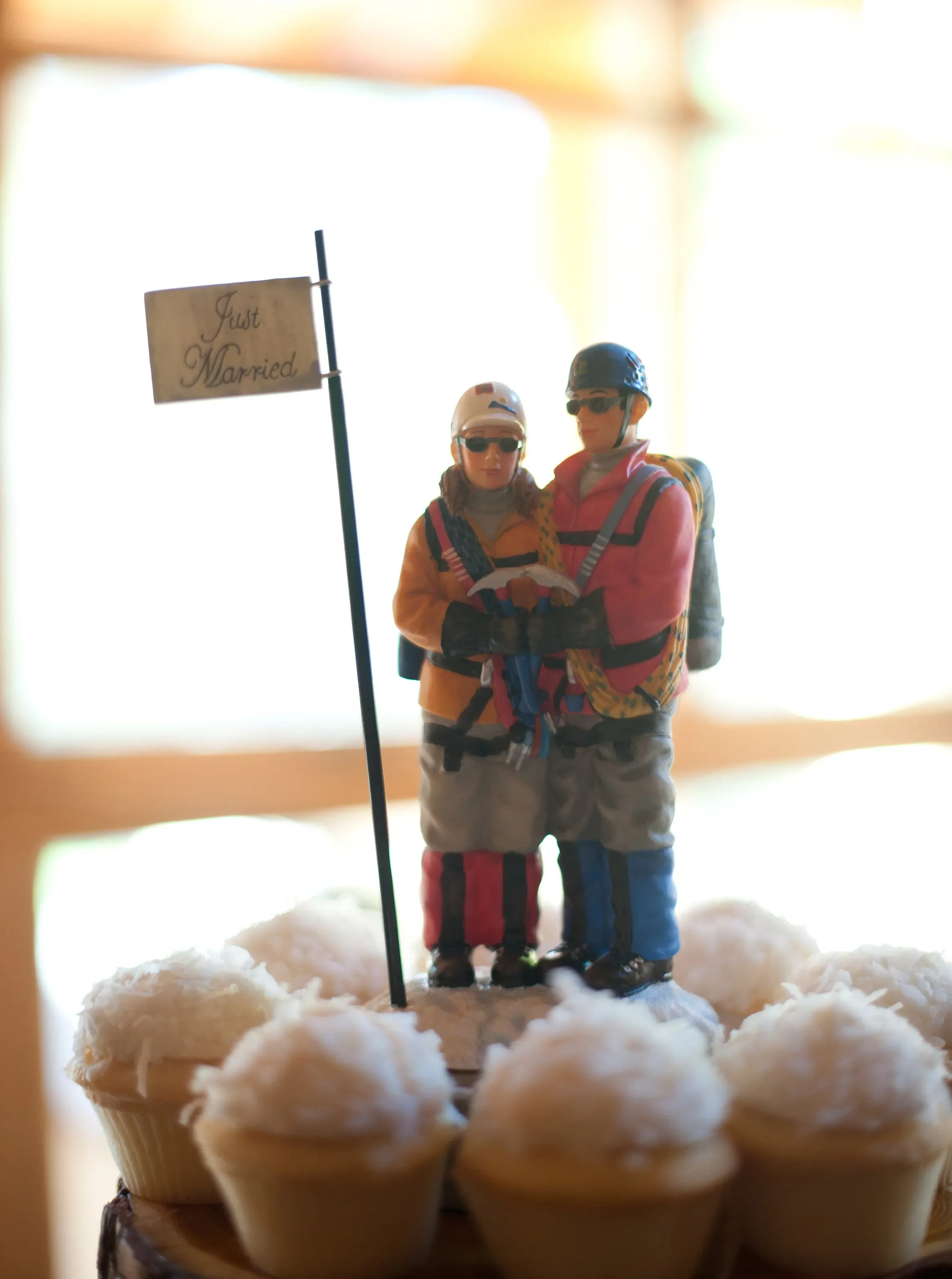 A Just Married flag and mountaineer cake topper on a cupcake wedding cake, a nod to the adventurous spirit of couples who celebrate near Mount Rainier at Fjellsangin in Ashford, Washington