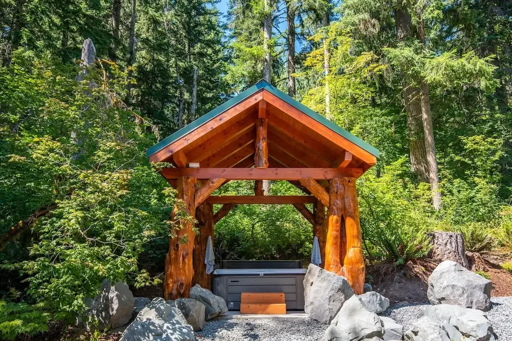 Covered hot tub pavilion with cedar log posts at Fjellsangin, hot tub cabin Washington