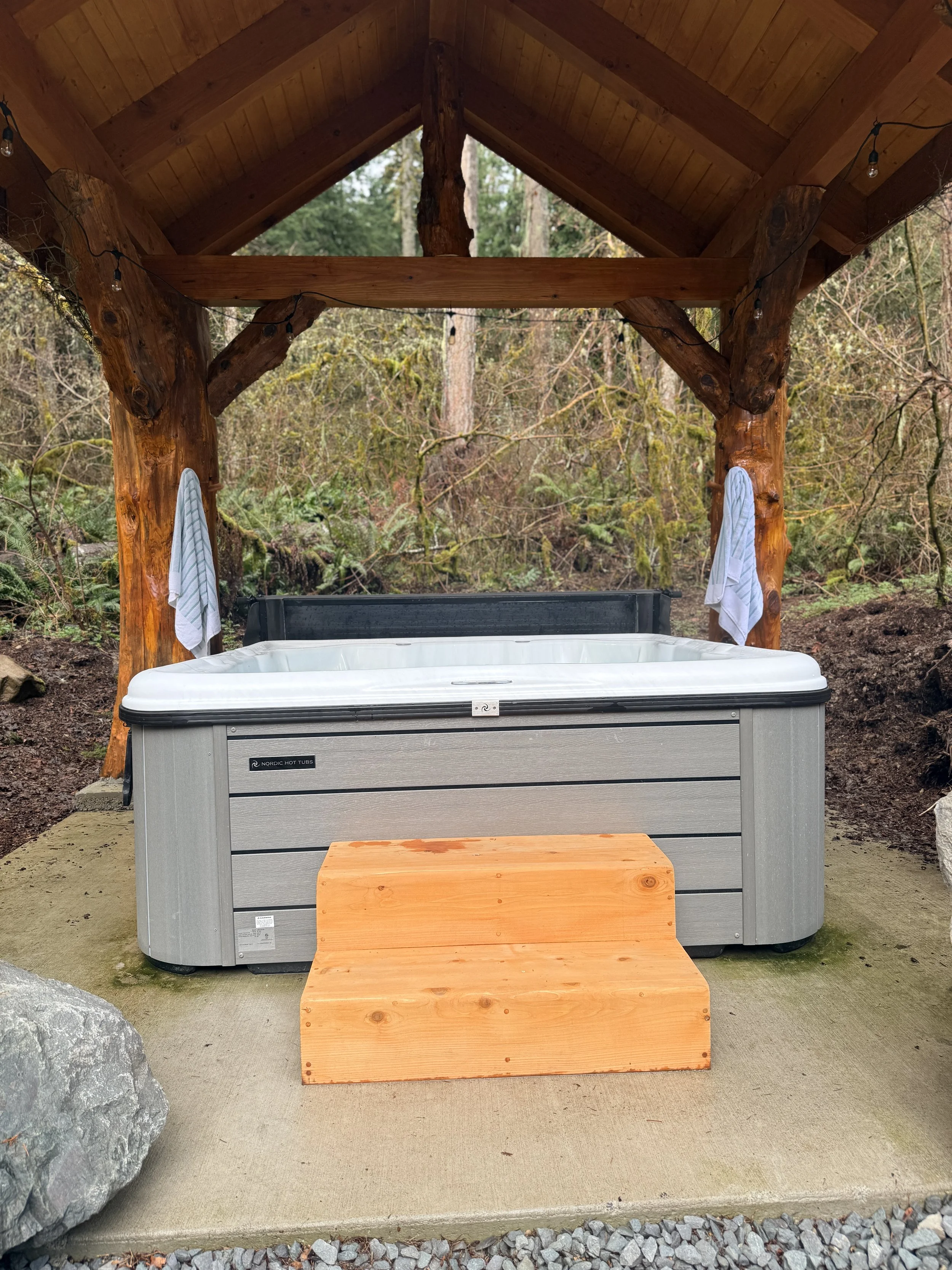 Hot tub and cover inside the cedar-post pavilion at Fjellsangin cabin in Ashford WA