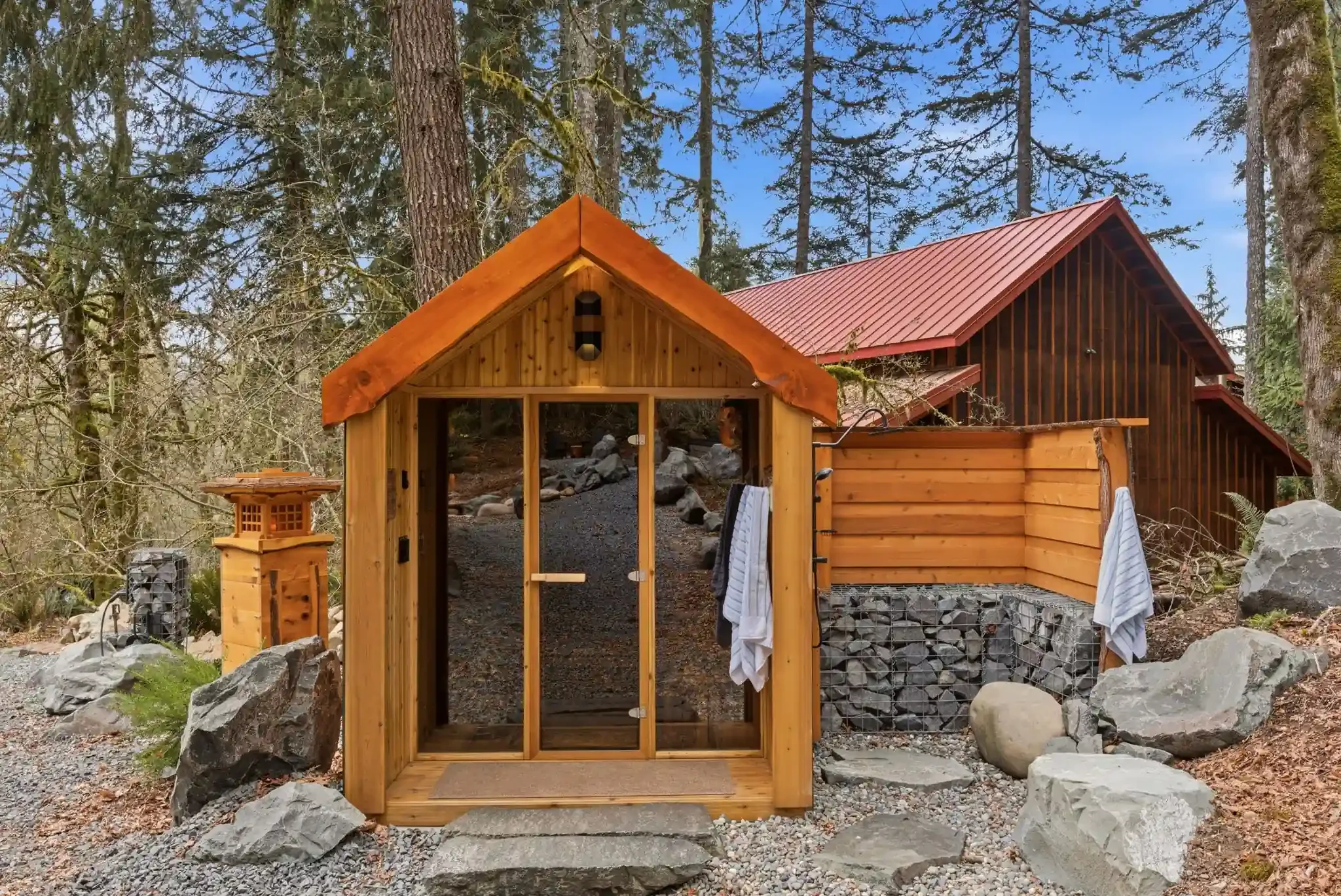 Cedar outdoor shower building surrounded by old-growth forest at Fjellsangin