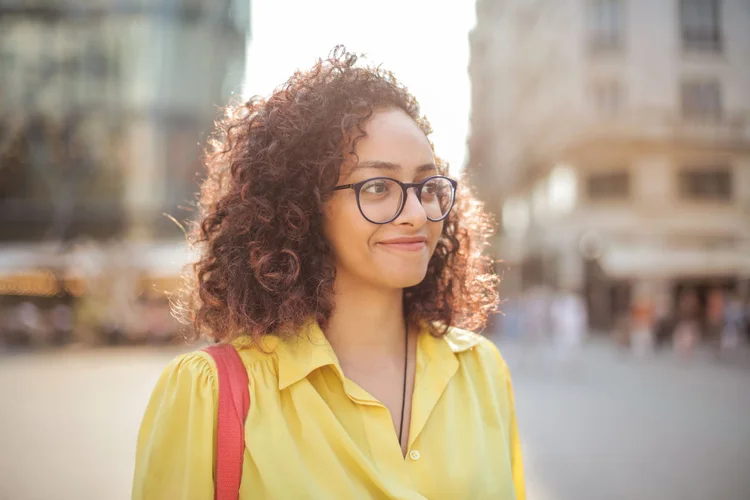 A young woman standing outdoors in warm afternoon light