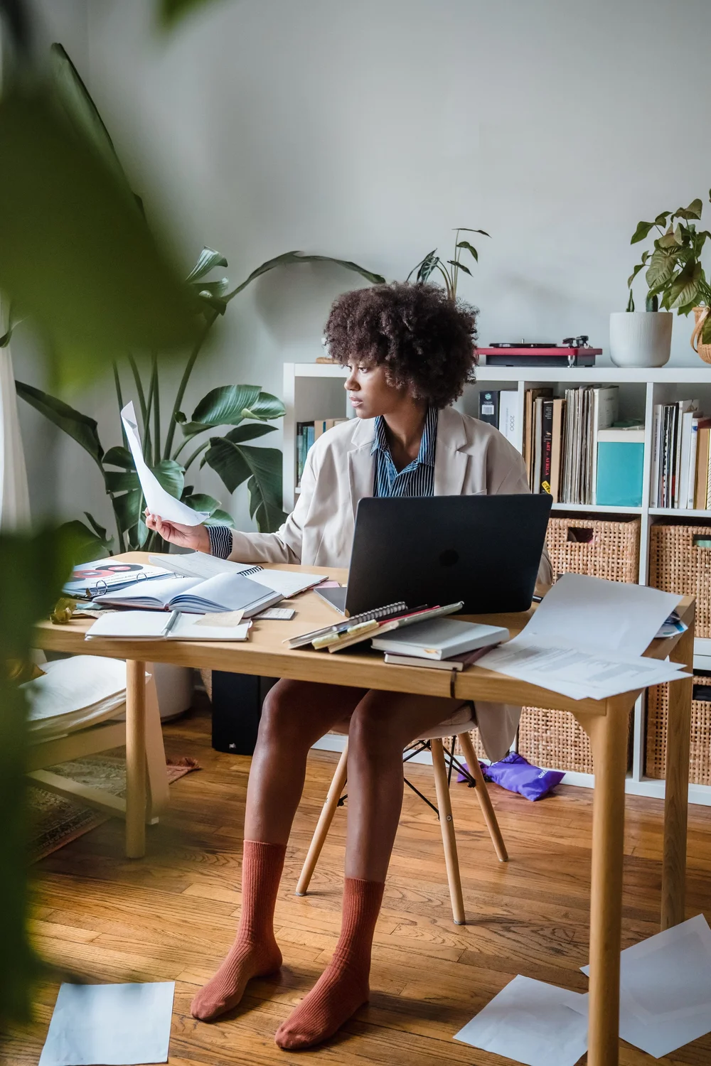 A woman working through paperwork at a desk in her home