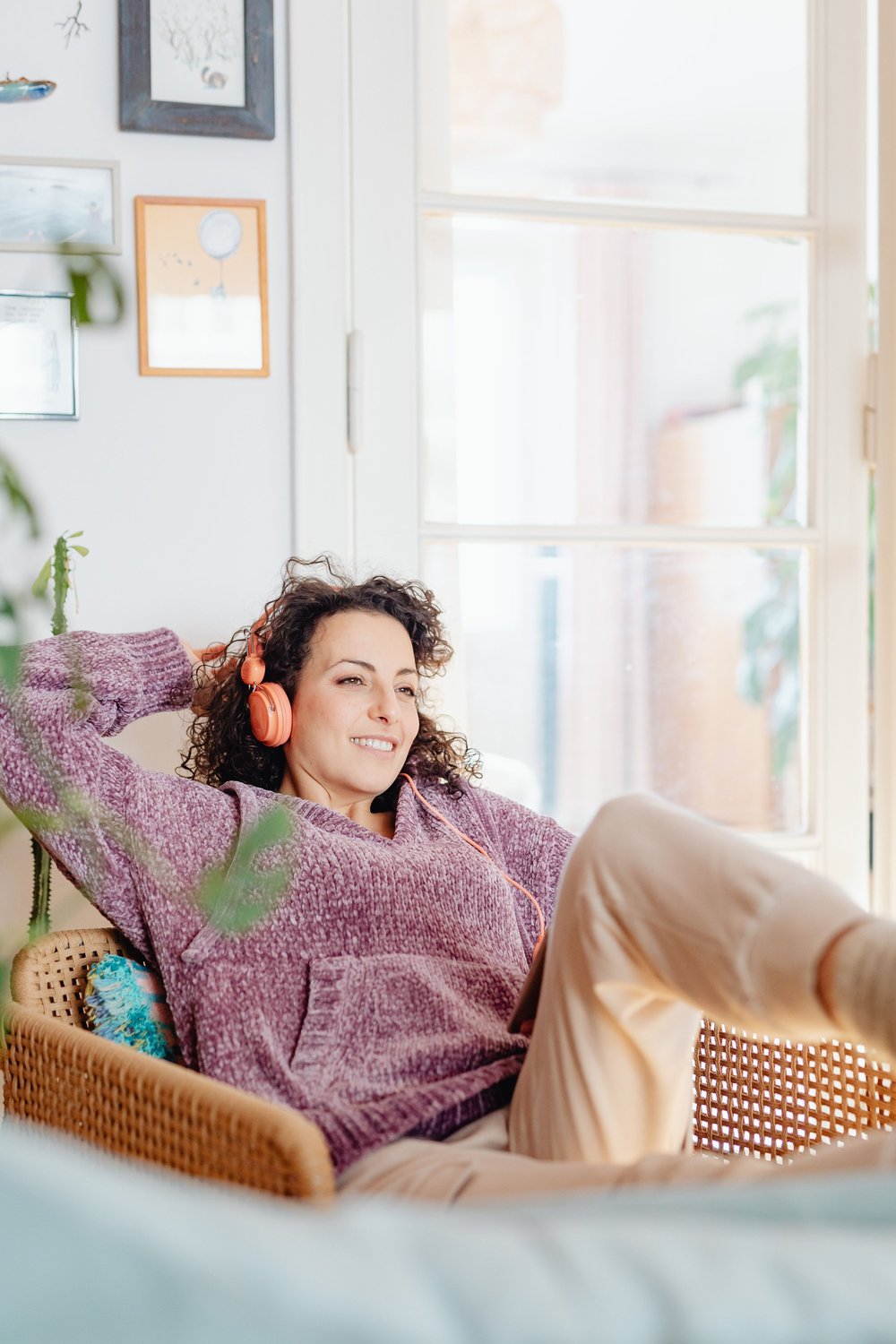 A woman sitting back in an armchair at home, at ease