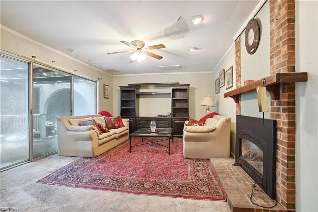 Modern living room staging and renovation by JDK Strategic Solutions, featuring a brick fireplace and open-concept design.
