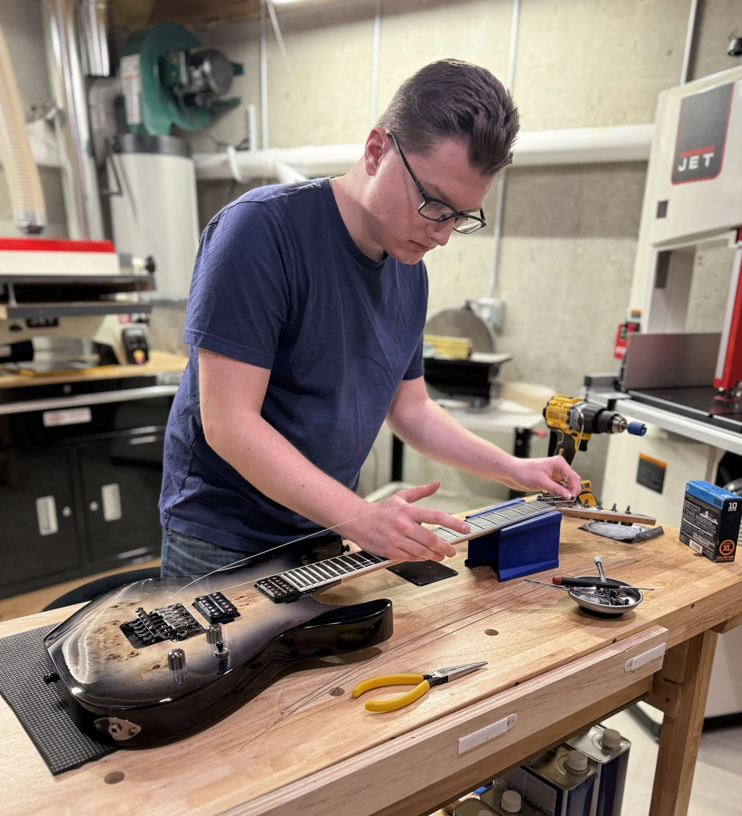 Connor in the shop performing a setup on a Floyd Rose-equipped Jackson guitar.