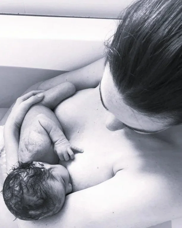 Mother breastfeeding her newborn during a follow-up lactation consultation