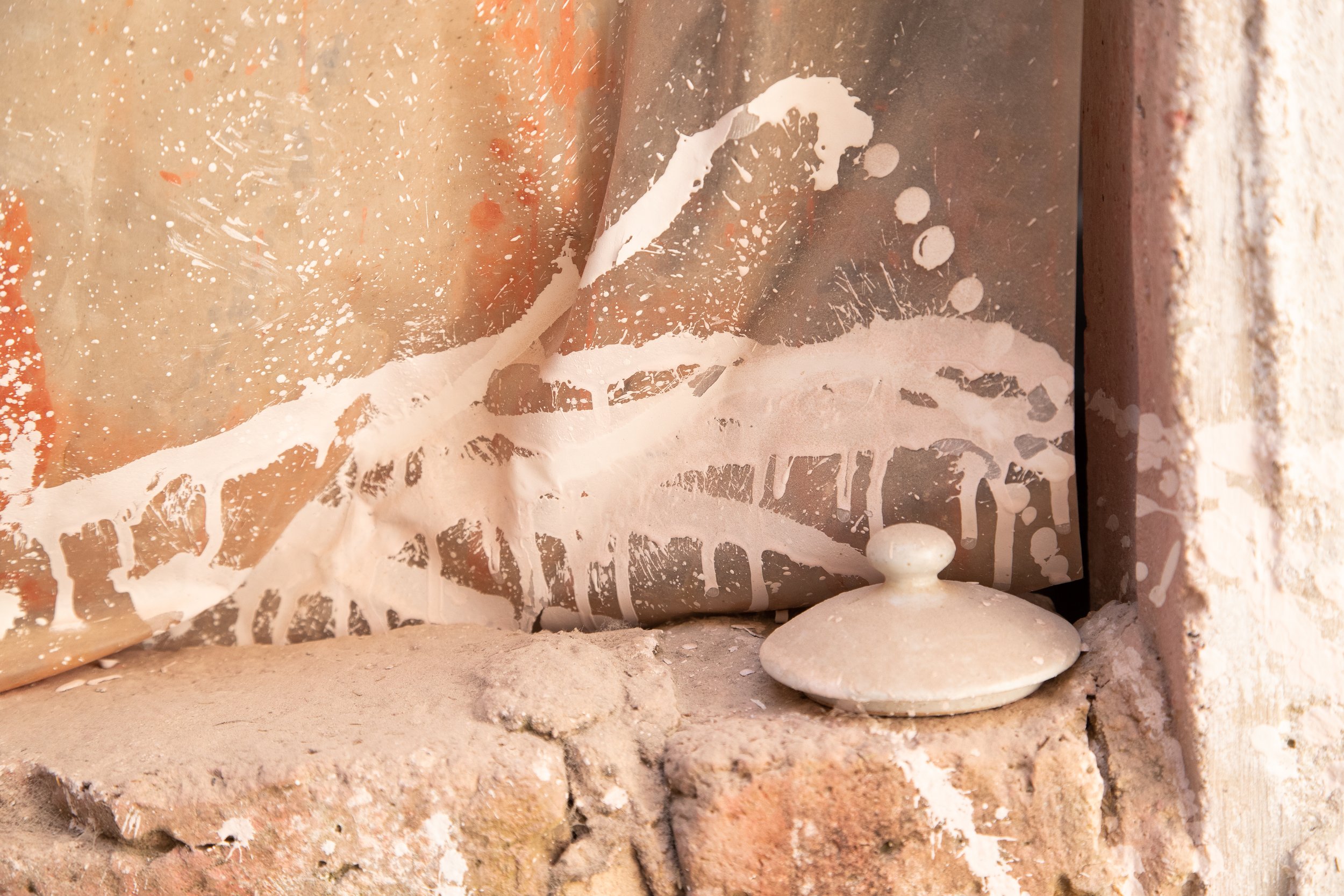 Abstract wall with paint splatters and stone object