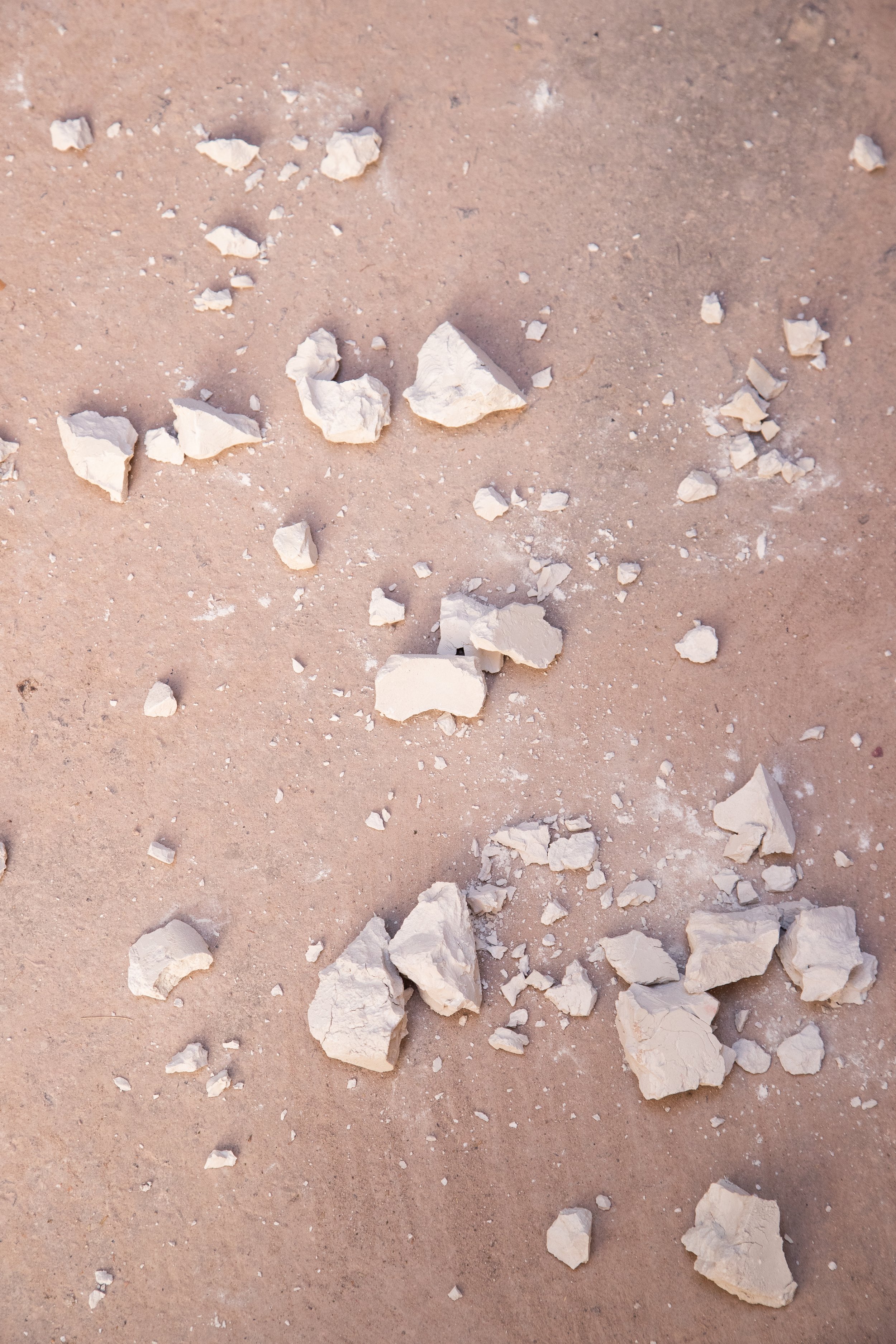White chalk pieces scattered on a beige surface