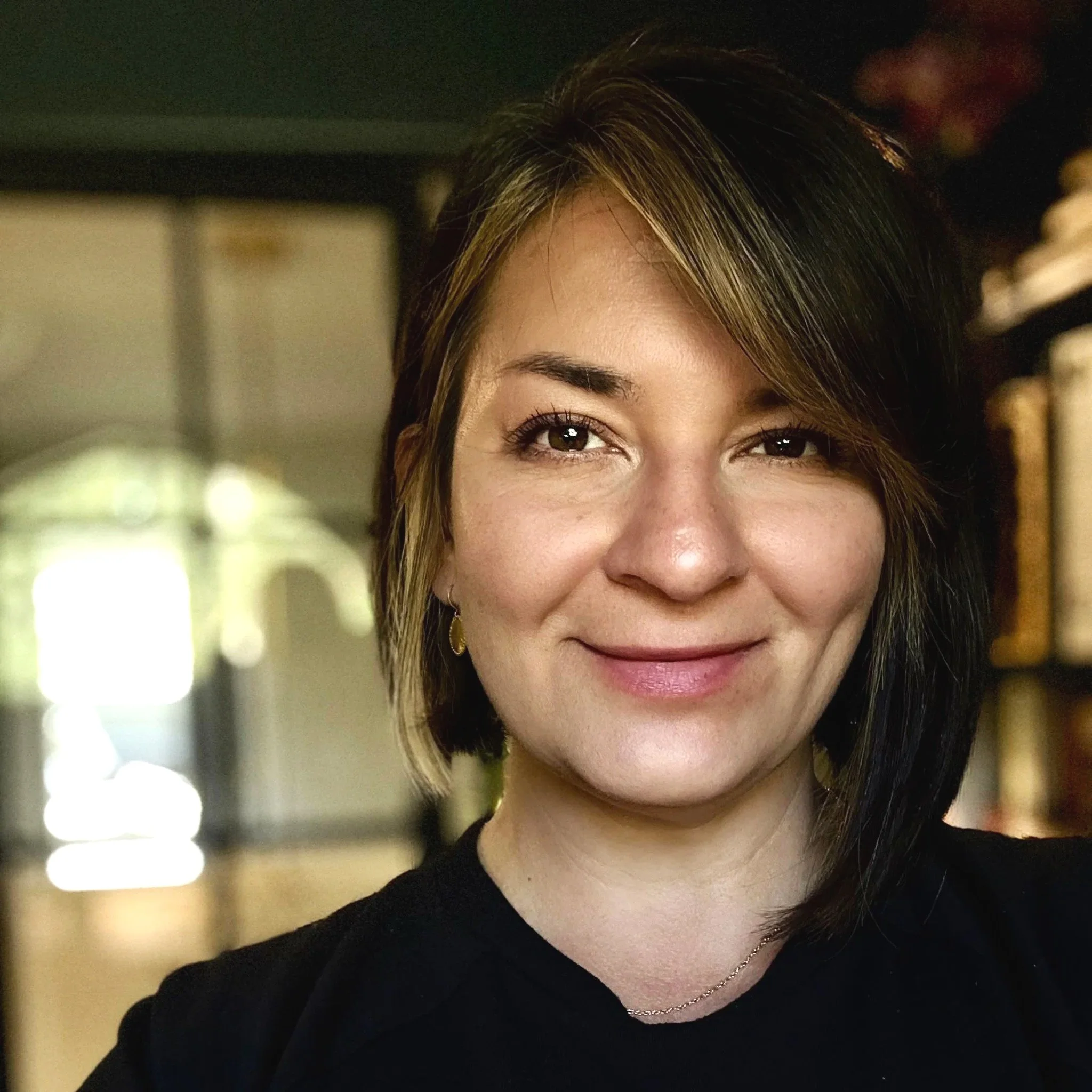 Image of Ksenia Boyer, relationship consultant and facilitator, The Papercut Effect. - 40's womain with medium brown and highlighted bob. Smiling into the camera