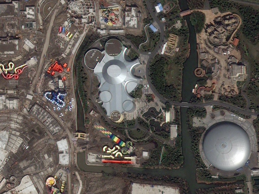Aerial view of the California Science Center featuring the Space Shuttle Endeavour exhibit, with surrounding buildings, water bodies, and amusement rides.