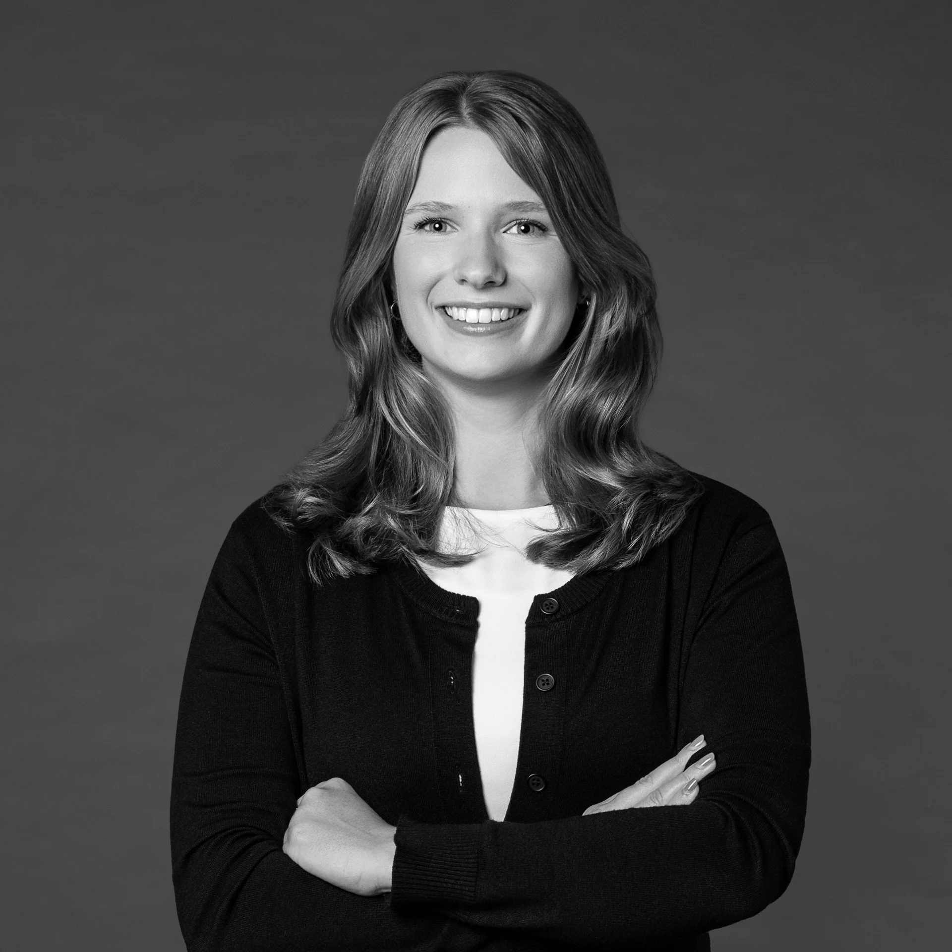 Black and white professional headshot of a smiling woman in business attire a collared shirt.