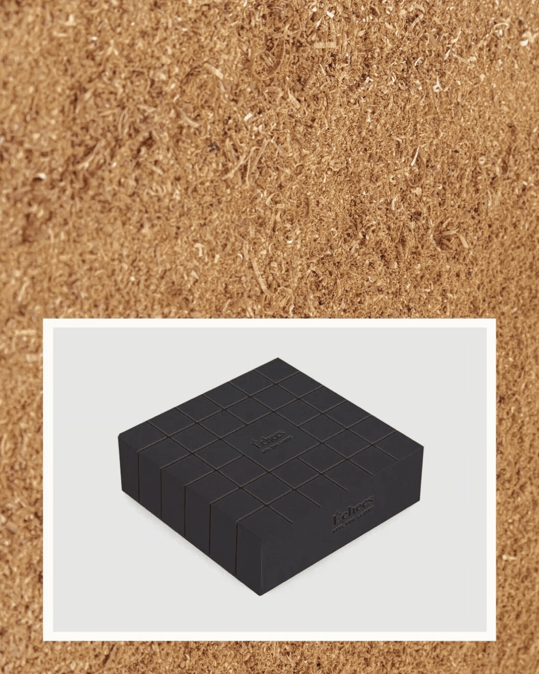 Premier plan, une surface de sable ou de poussière avec quelques petits objets et tracés, en arrière-plan, une boîte noire de forme rectangulaire avec un motif de carreaux gravés dessus, portant la marque 'iChocs'.