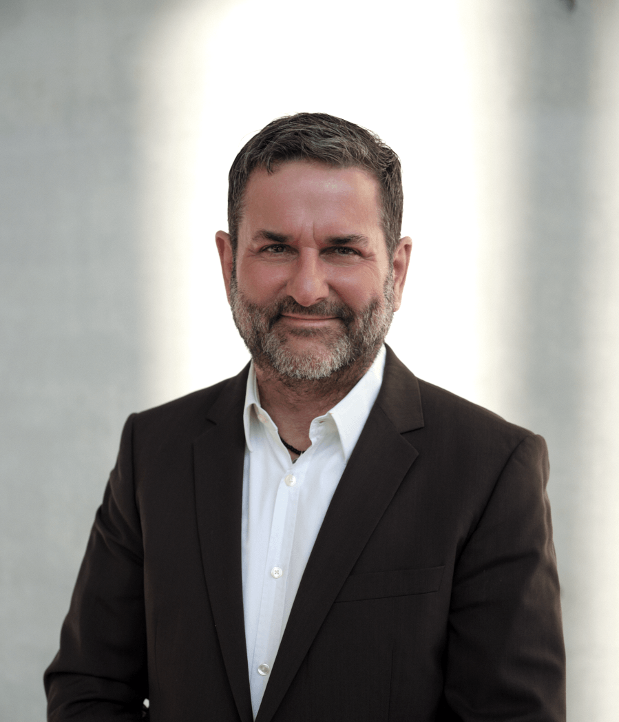 Mann mit weißem Hemd und braunem Sakko vor einem hellen Licht, Sinnbild für mentale Gesundheit, Resilienz und Burnout-Prävention in München