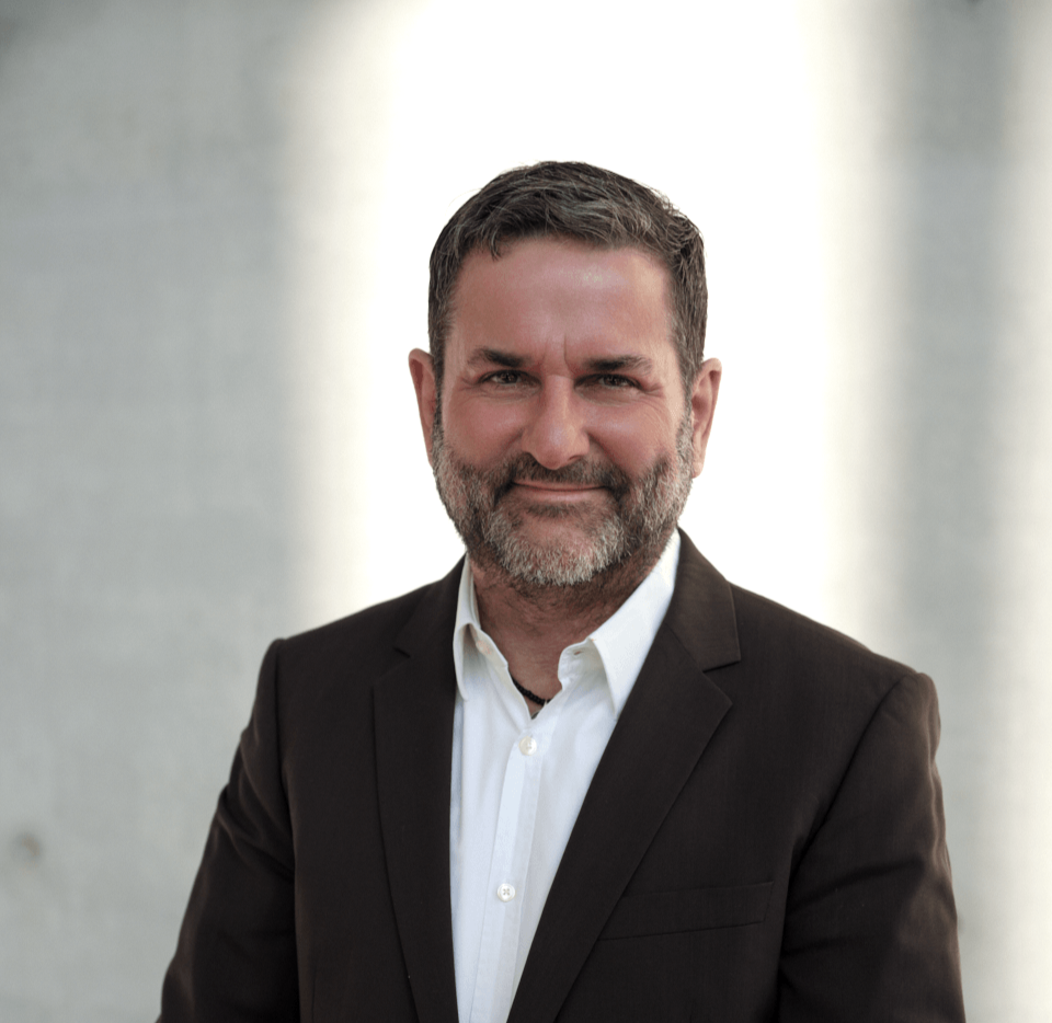 Mann mit weißem Hemd und braunem Sakko vor einem hellen Licht, Sinnbild für mentale Gesundheit, Resilienz und Burnout-Prävention in München