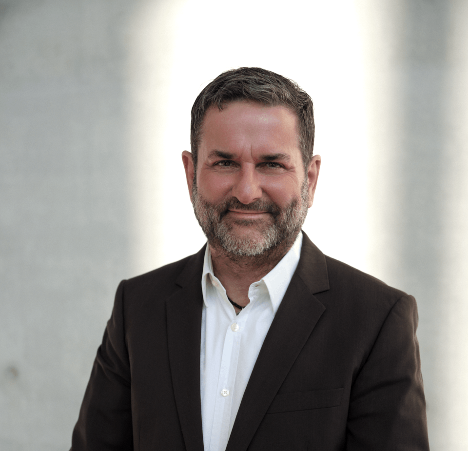 Mann mit weißem Hemd und braunem Sakko vor einem hellen Licht, Sinnbild für mentale Gesundheit, Resilienz und Burnout-Prävention in München