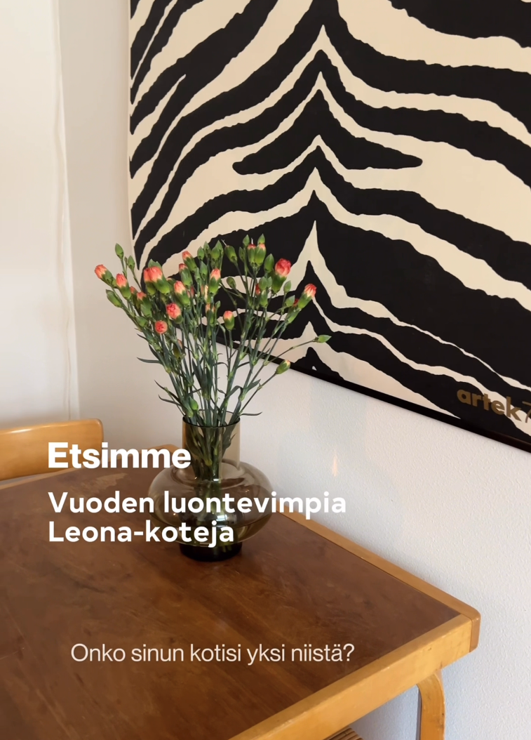 Ruokapöytä, jonka päällä on maljakko kukkia. Seinällä on mustavalkoinen zebra-taulu.