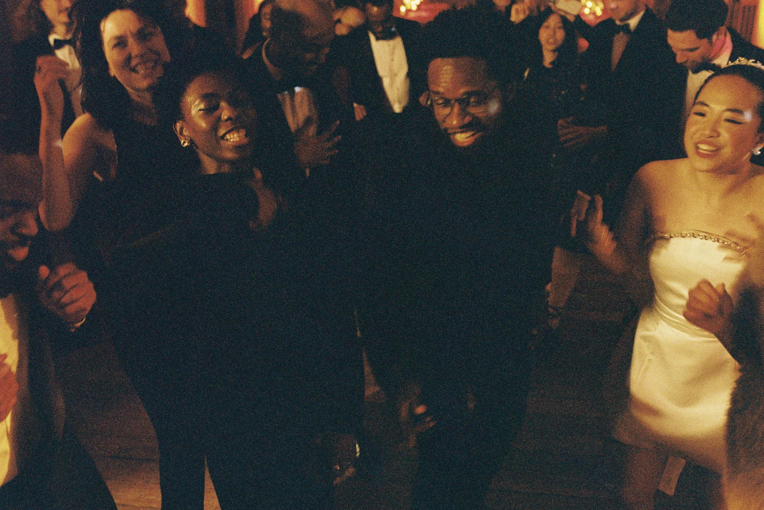 guest on the dance floor film photo multiracial diverse group of guests black tie international destination wedding in UK London