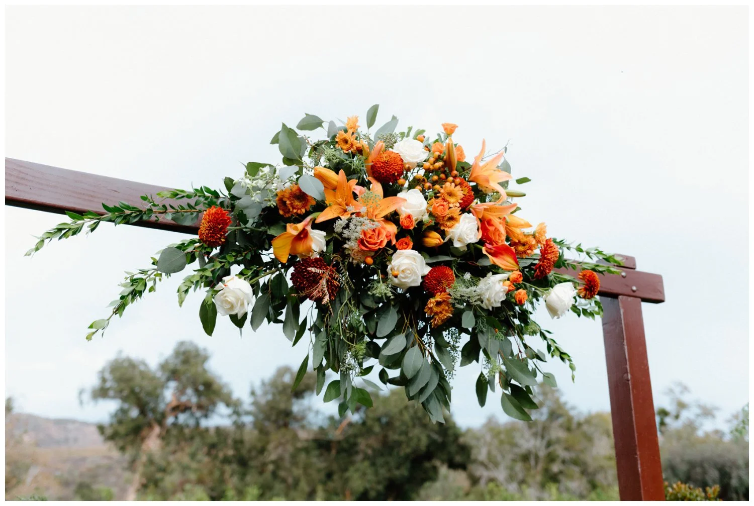 rust orange, cream, and green fall boho floral arch