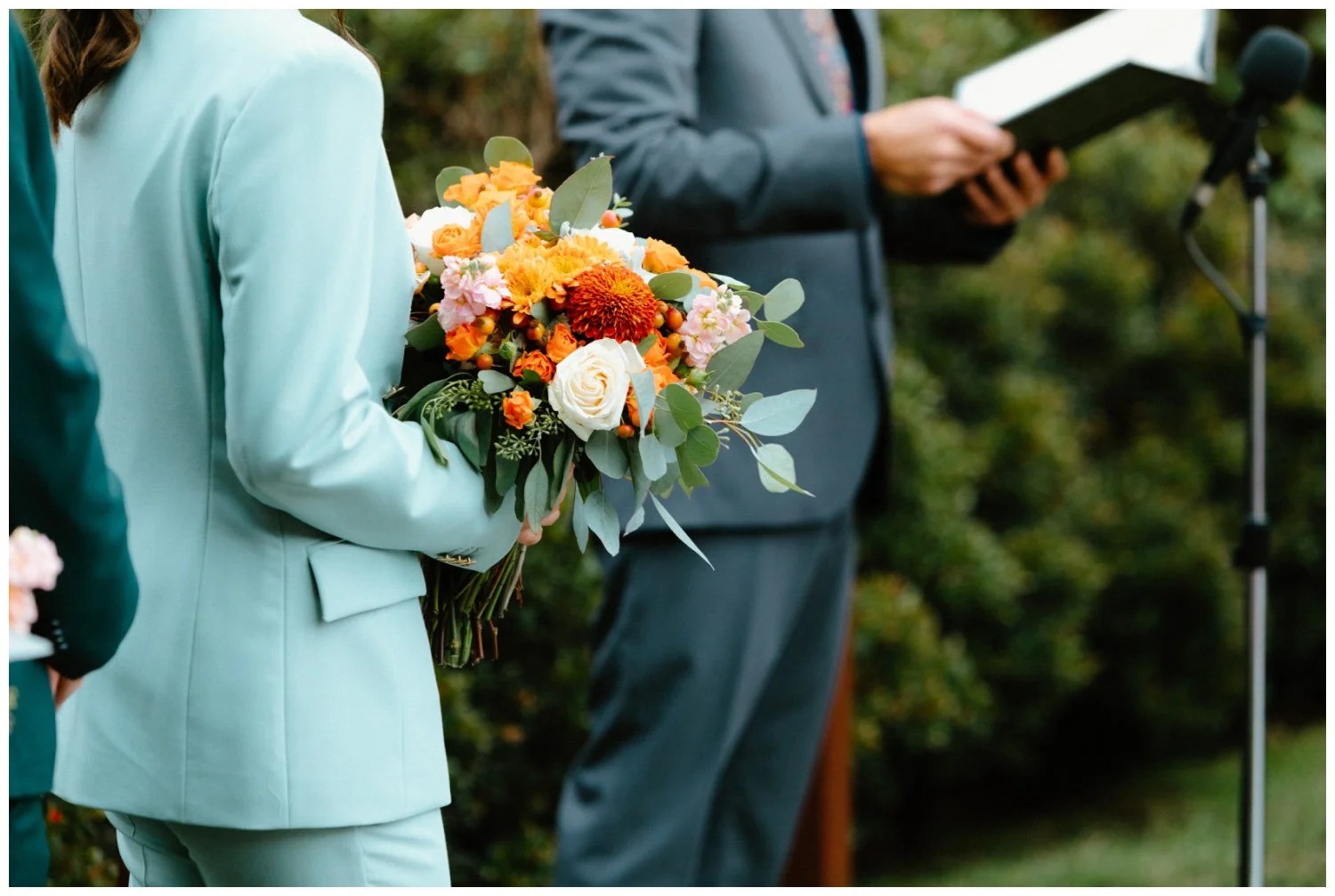 vibey maid of honor teal suit holding orange boho bouquet