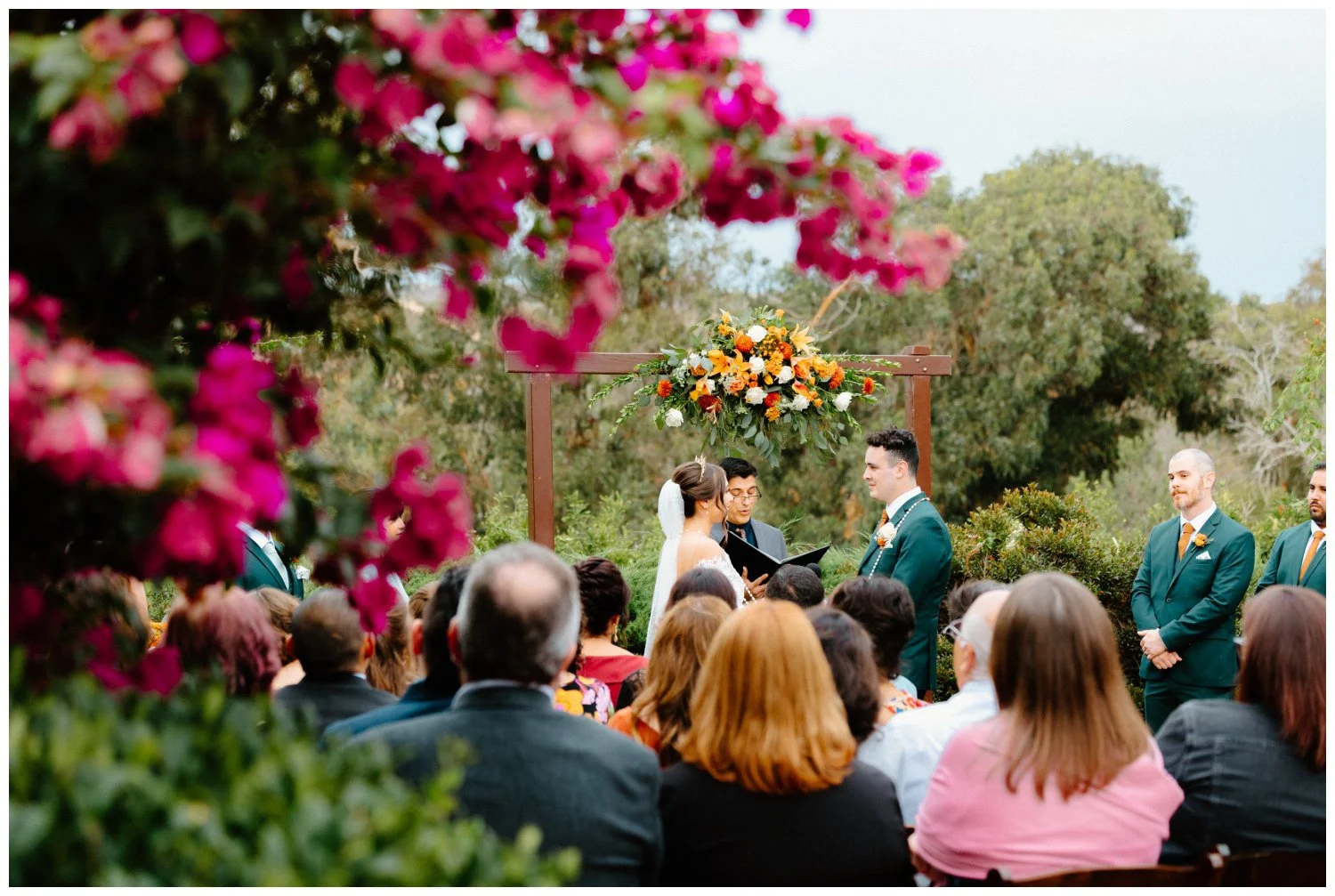 pov through the flowers of ross and belen's boho chic wedding ceremony