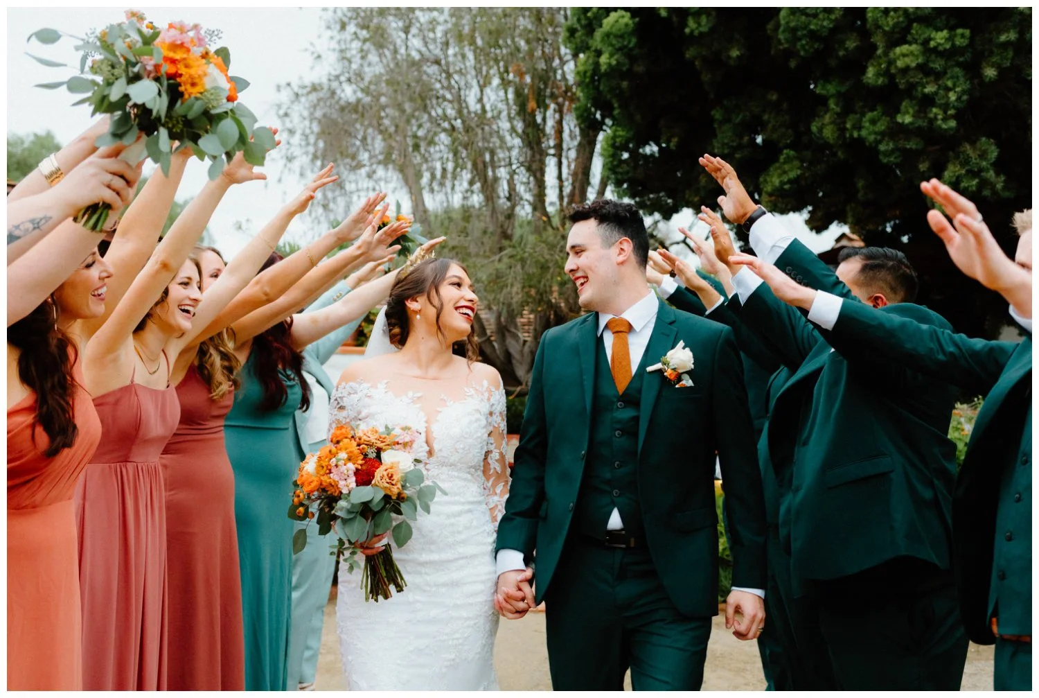 bride and groom run through wedding party tunnel