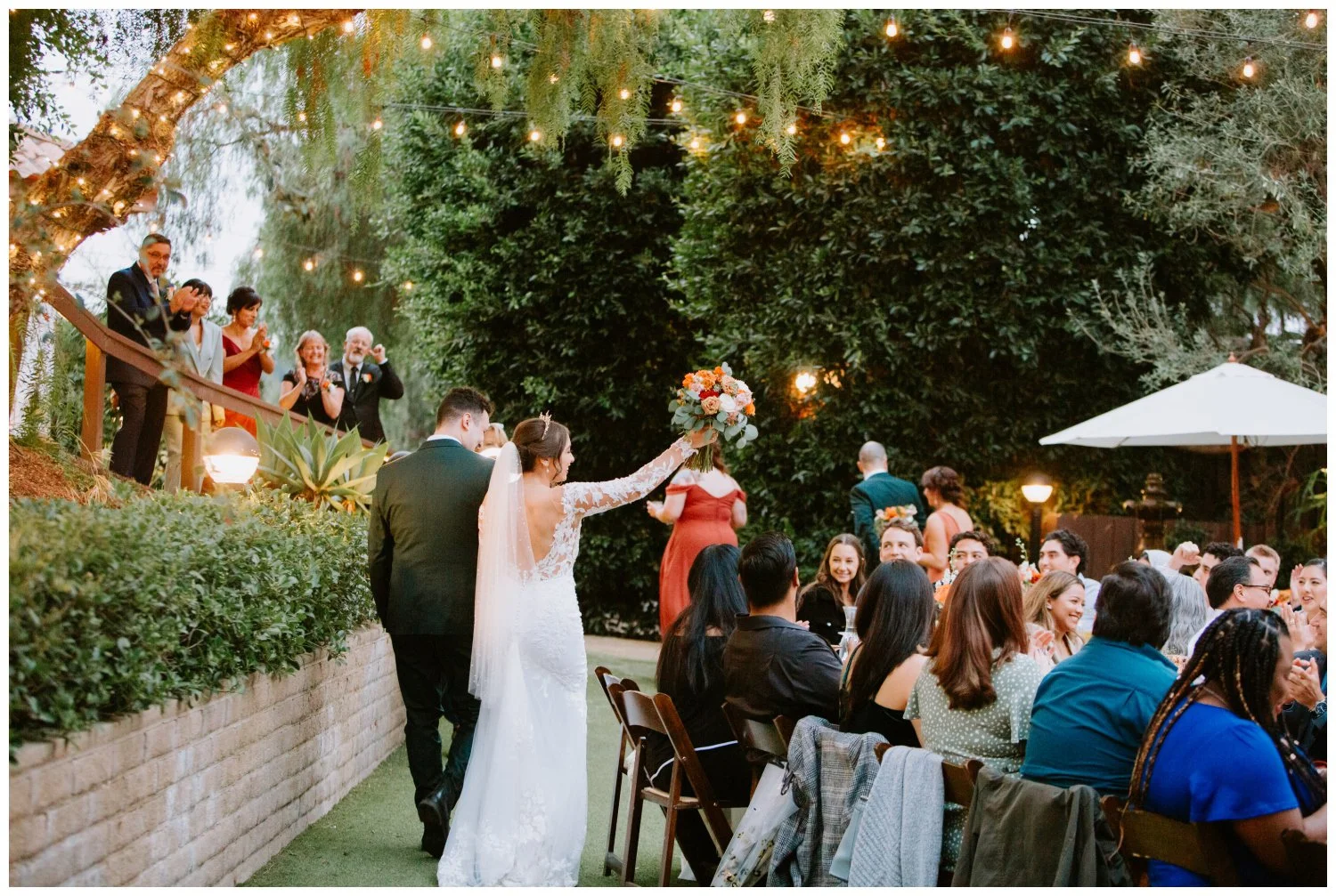 Bride and groom enter reception and wave at guests