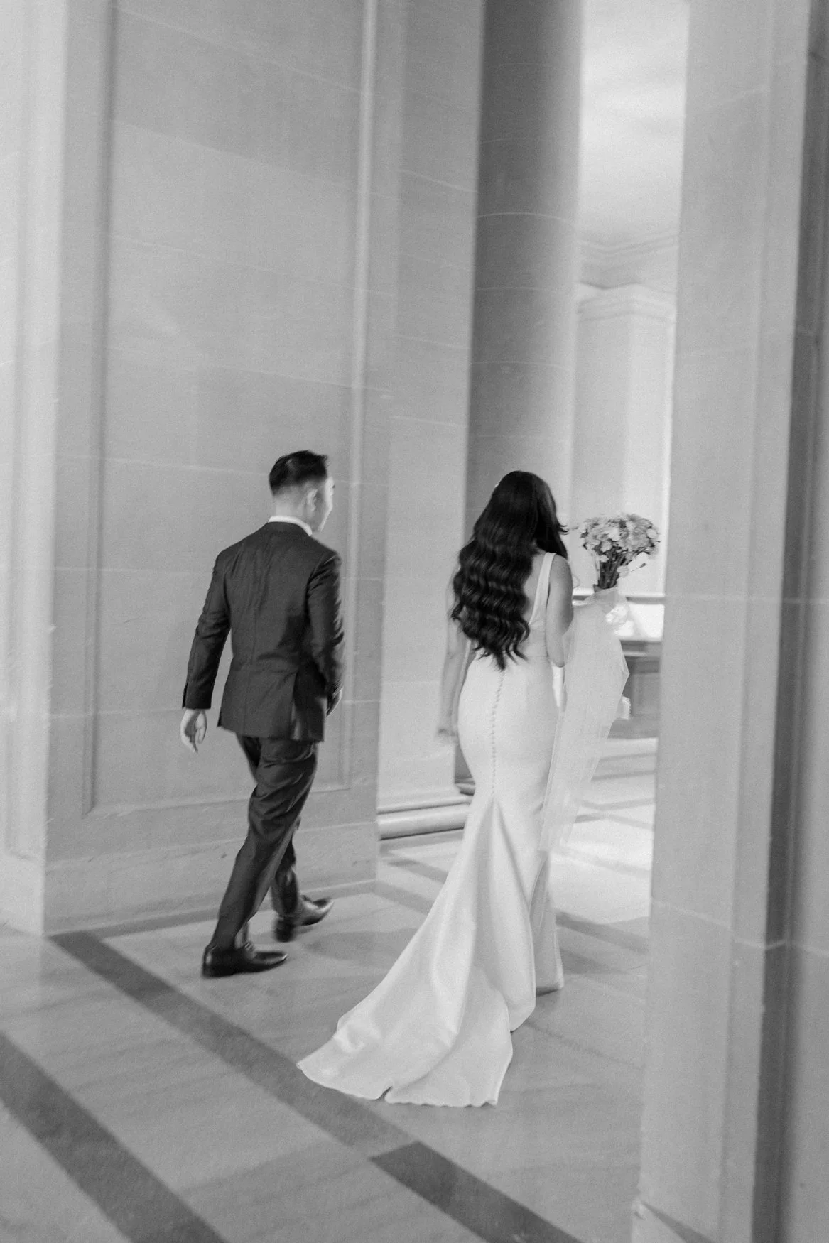 Jonathan and Carla walking towards their ceremony site in San Francisco City Hall, motion blur 35mm film photo