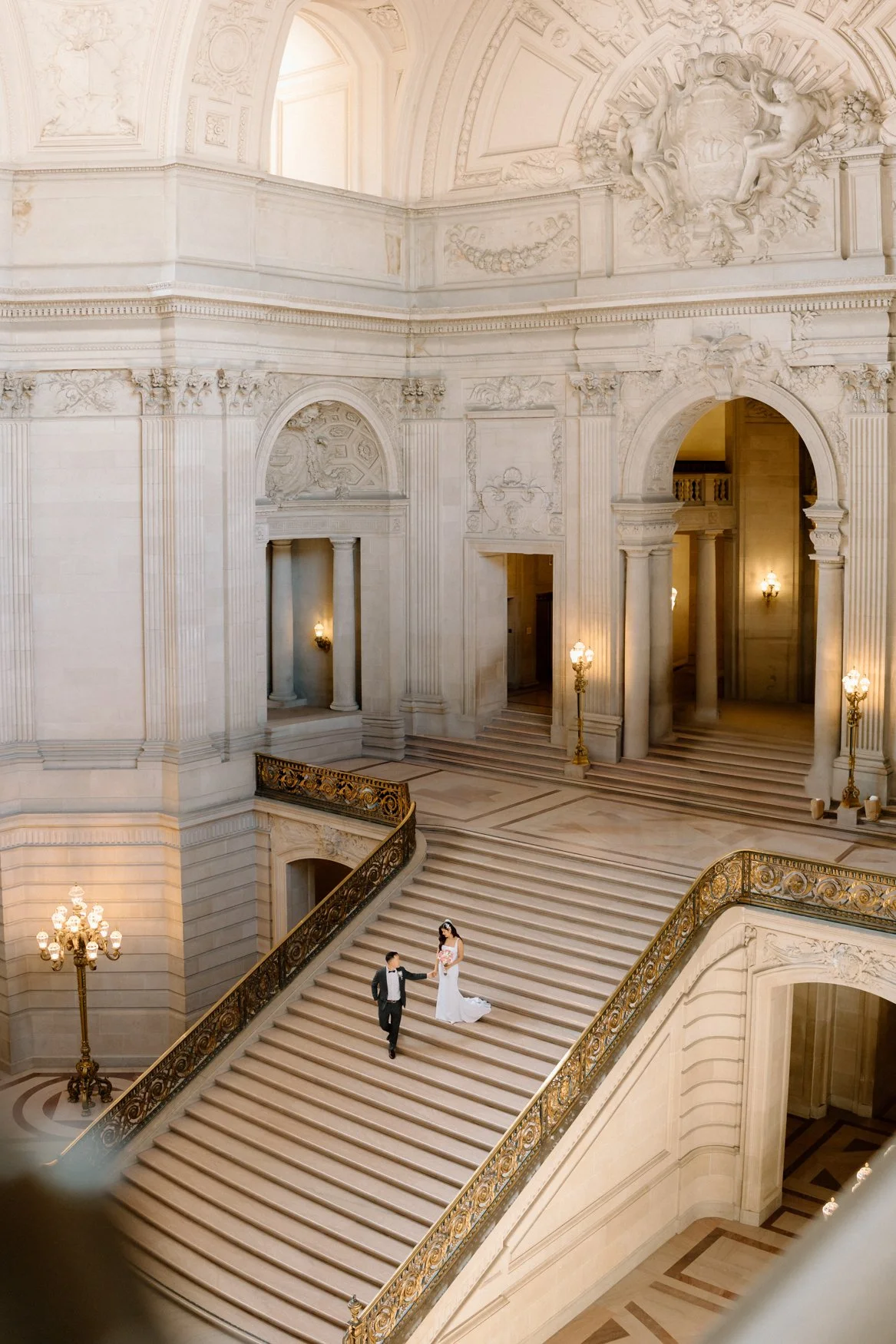Jonathan and Carla walk down the grand staircase at San Francisco City Hall