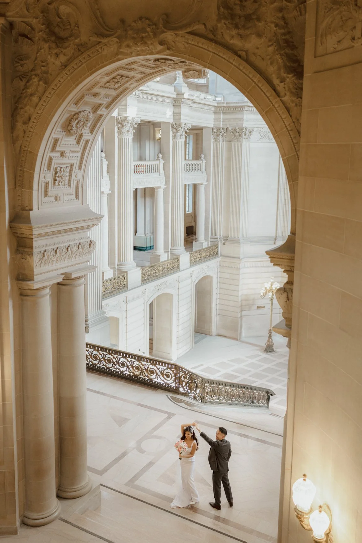Jonathan and Carla dance underneath the arches in San Francisco City Hall. Romantic Editorial Wedding photos