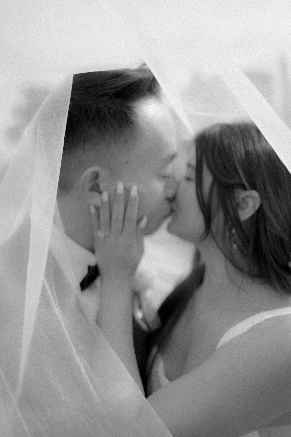 Blurry Artistic Photo of Bride and Groom underneath her veil in Baker Beach, San Francisco, CA