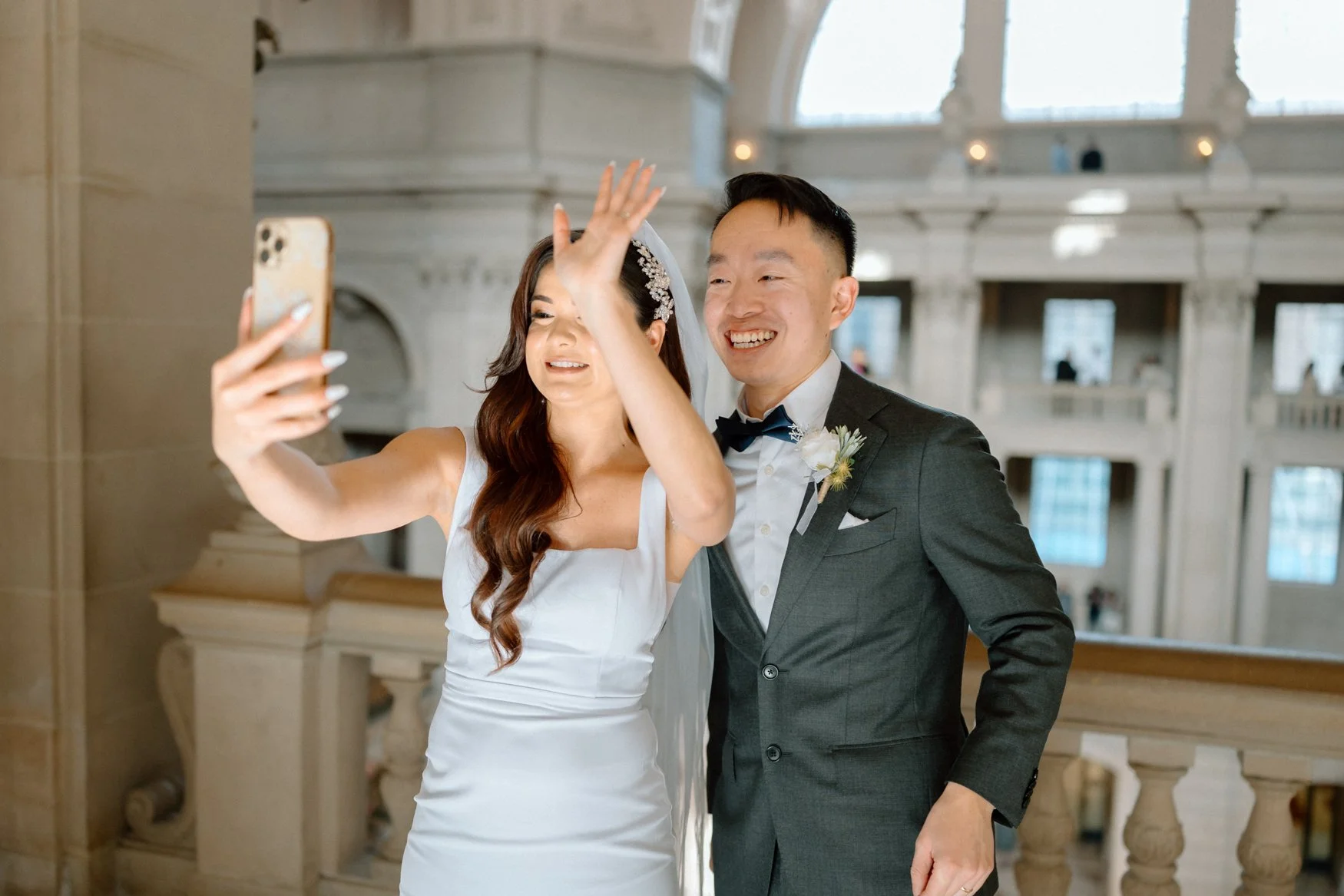Bride and Groom wave to their family on facetime after getting married in SF City Hall