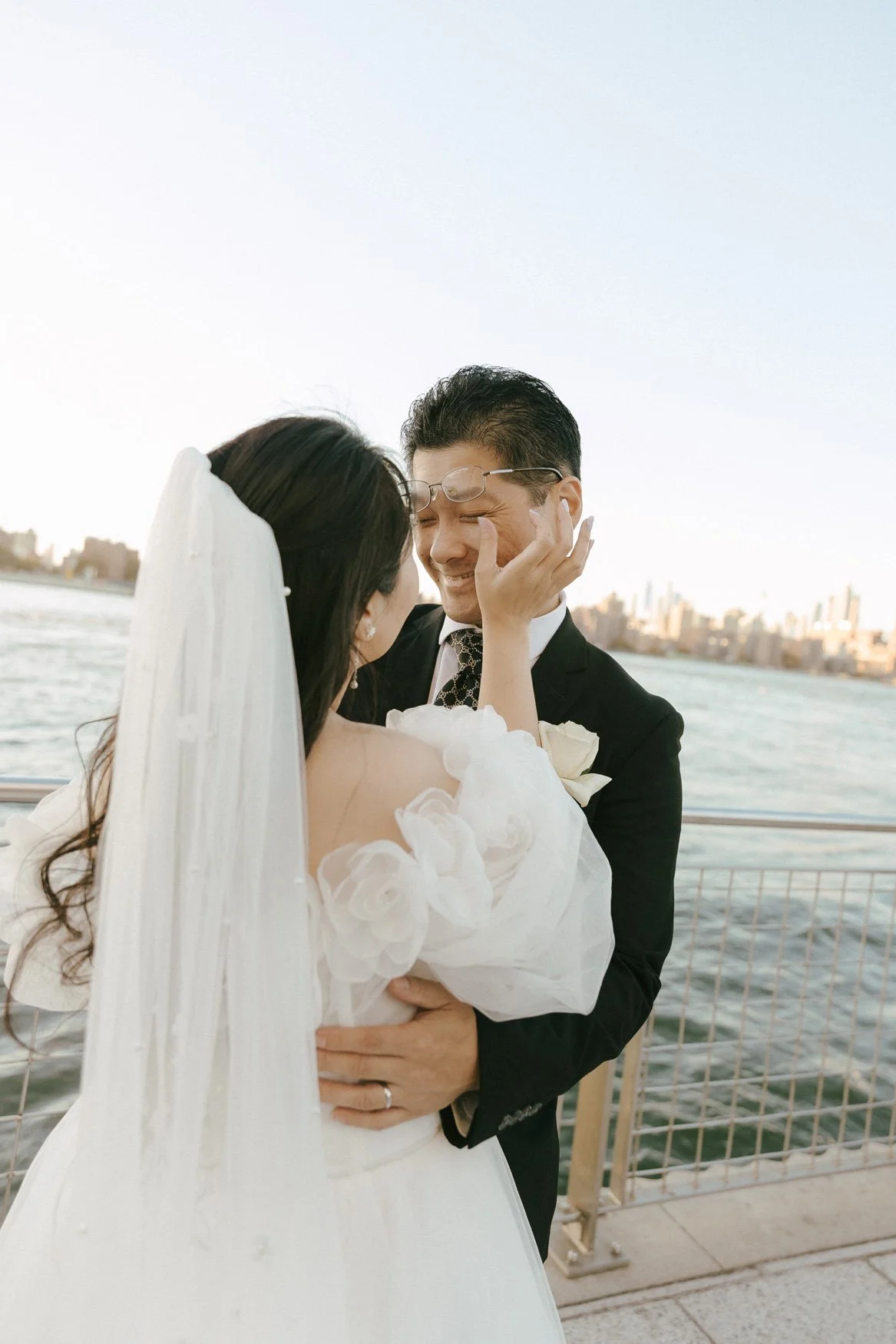 candid photo of bride wiping groom's tears