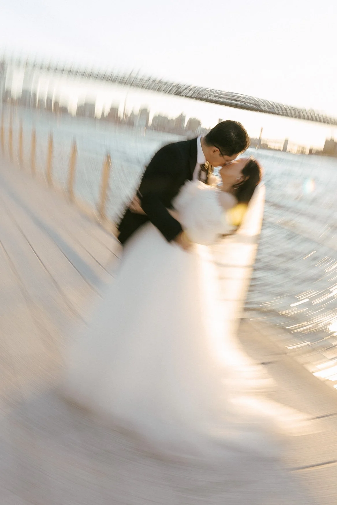 artistic motion blur photo of bride and groom kiss