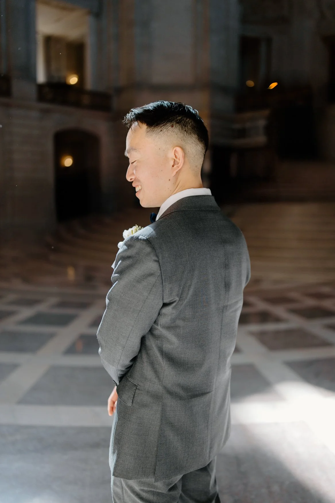 Groom in SF City Hall lobby with cinematic light